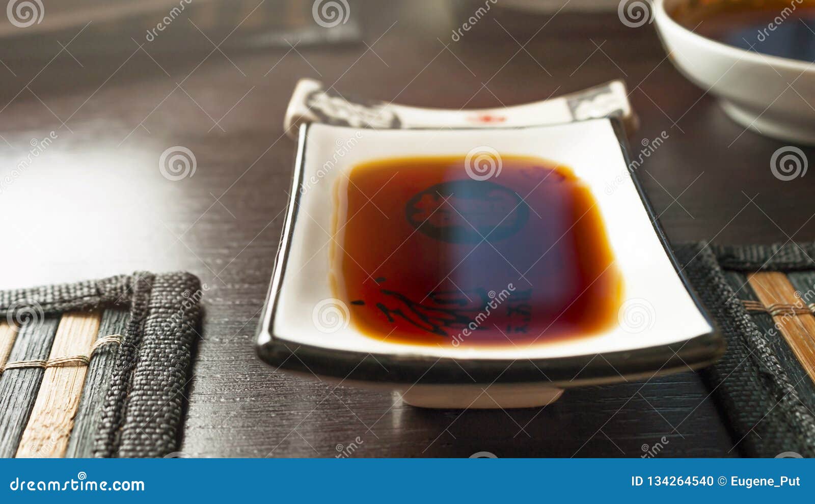 Rectangular Soy Sauce Dipping Dish on a Dark Table with Bamboo Dining