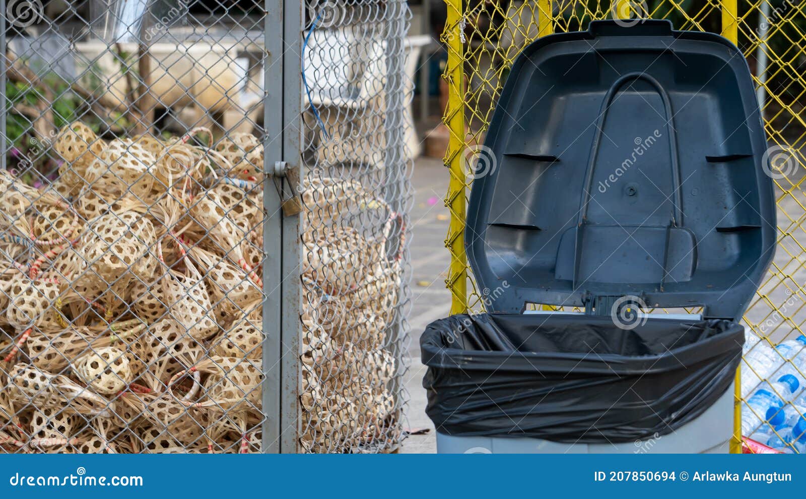 A Recycling Bin with Lots of Black Bags and Wicker Baskets Stock Photo