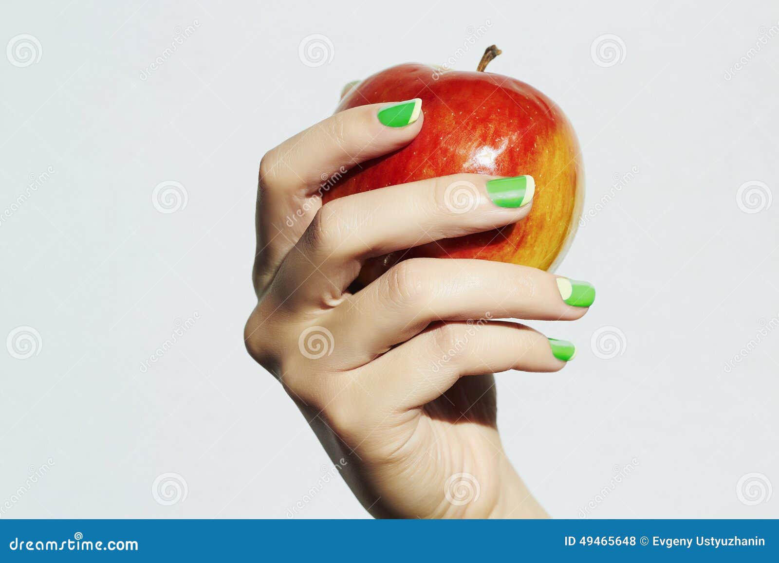 red apple in hand with manicure. female hands. beauty salon woman shellac polish