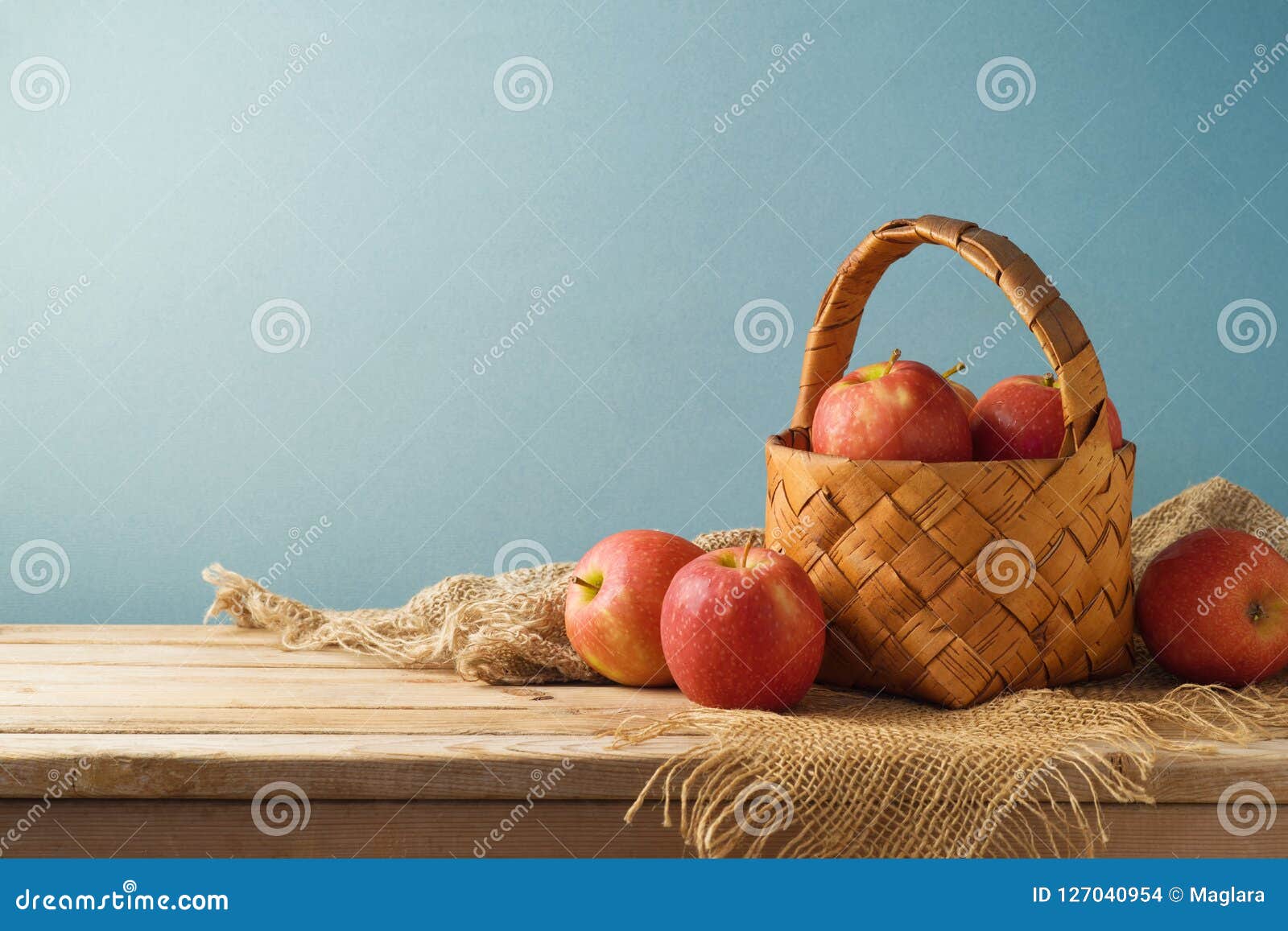 Red Apples in Basket on Wooden Kitchen Table Background Stock Photo