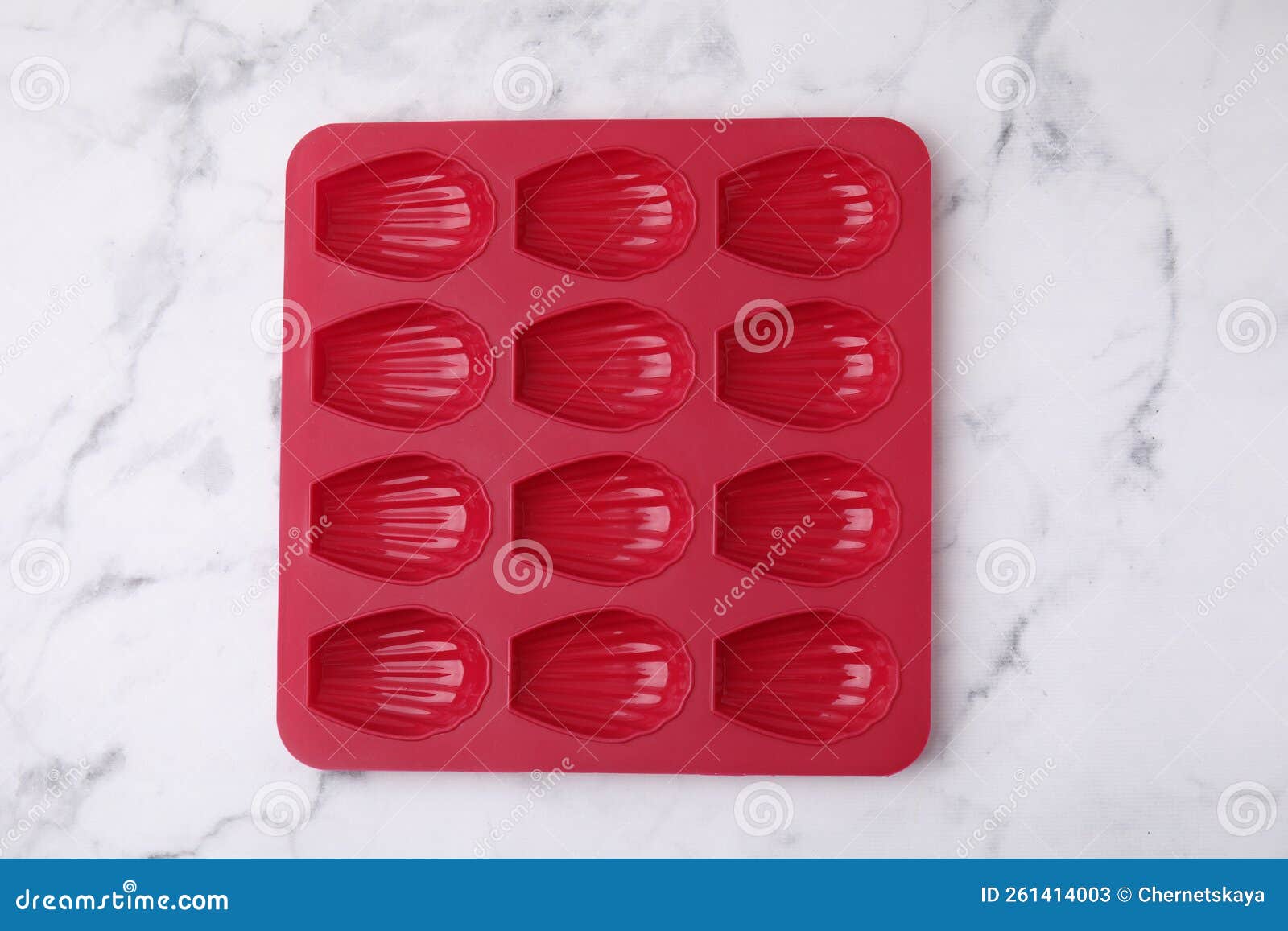 Red Baking Mold for Madeleine Cookies on White Marble Table, Top View