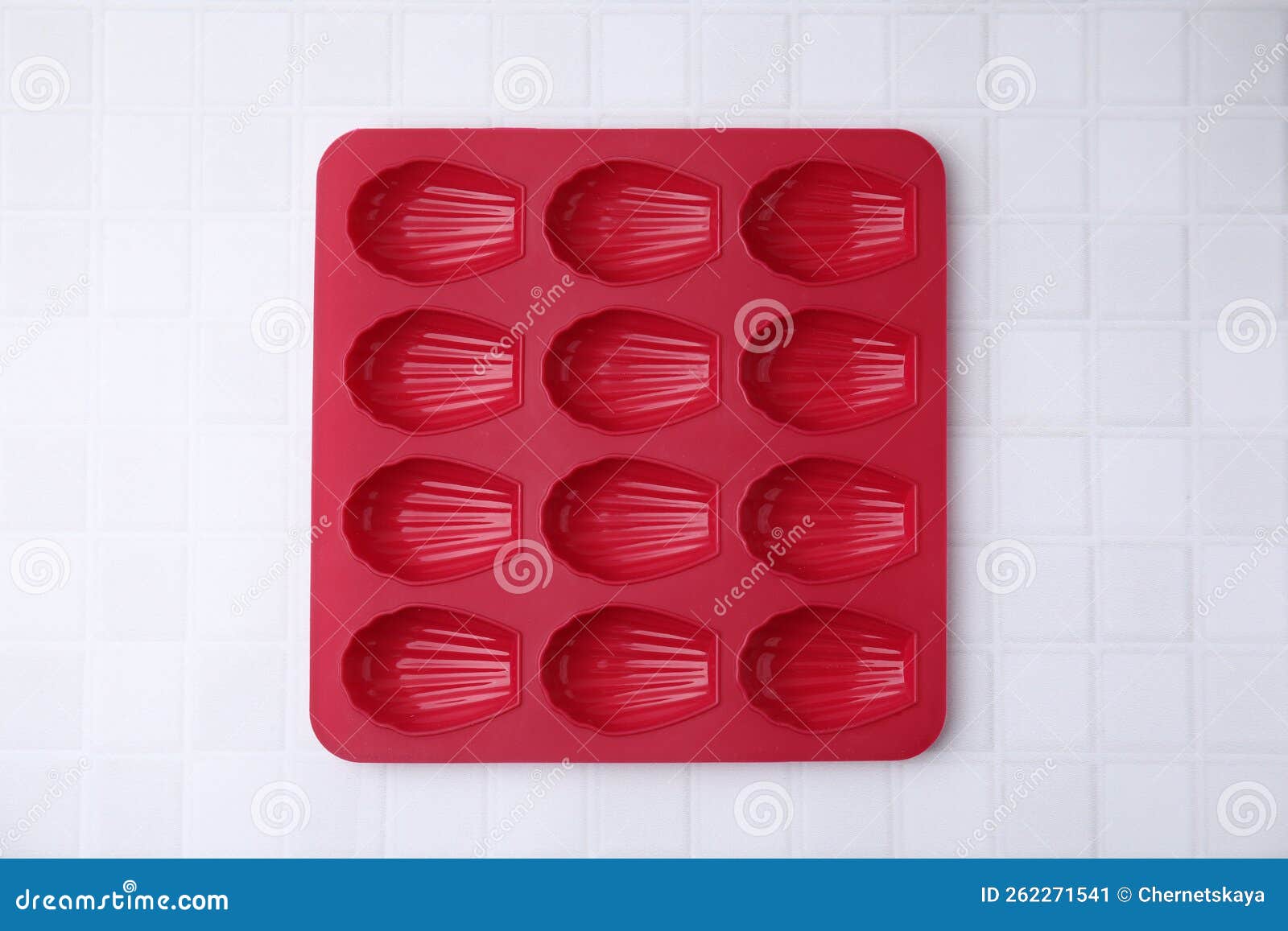 Red Baking Mold for Madeleine Cookies on White Tiled Table, Top View