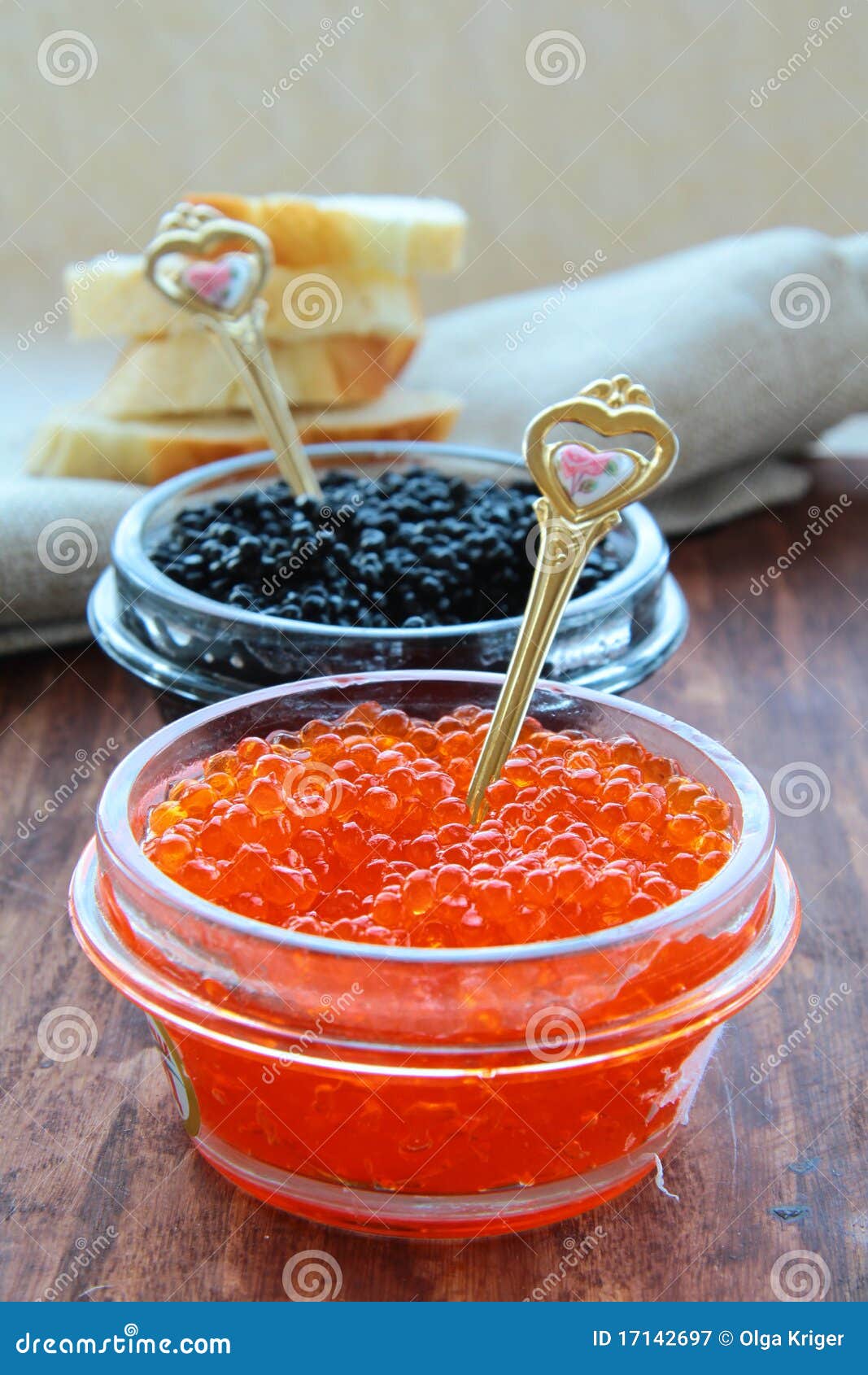 Red and black caviar in glass jars with gold spoons