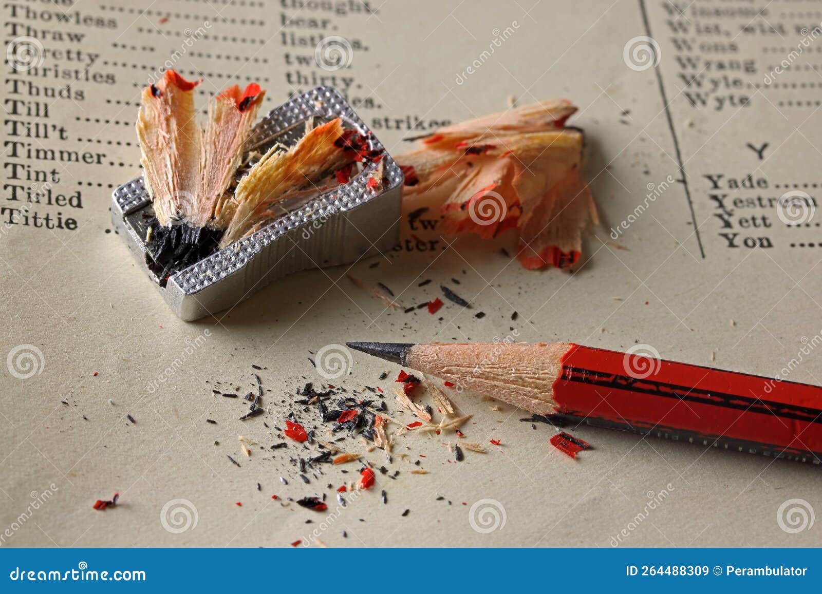 red and black sharpened pencil on a page displaying alphabetized description of words