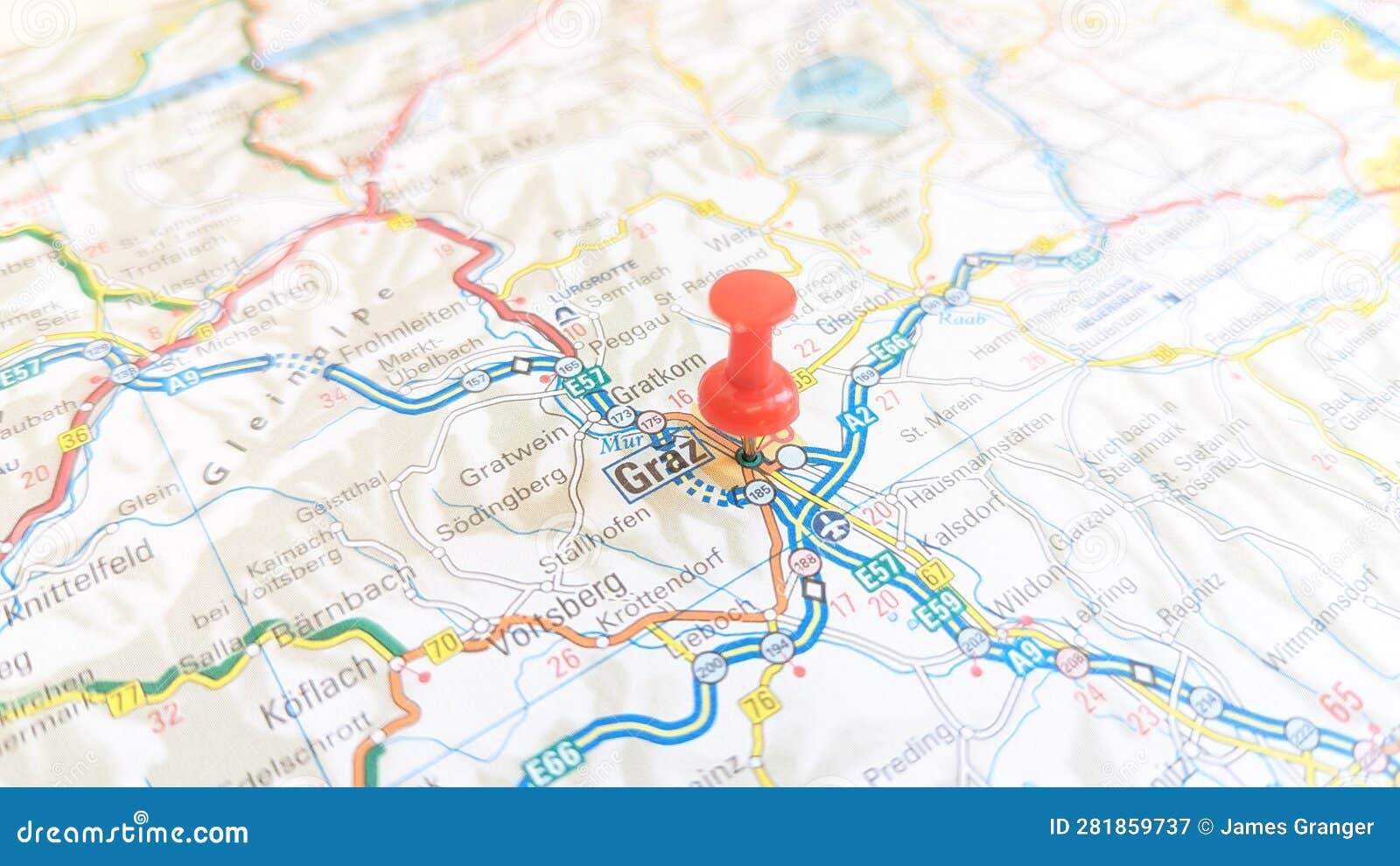 a red board pin stuck in graz on a map of austria