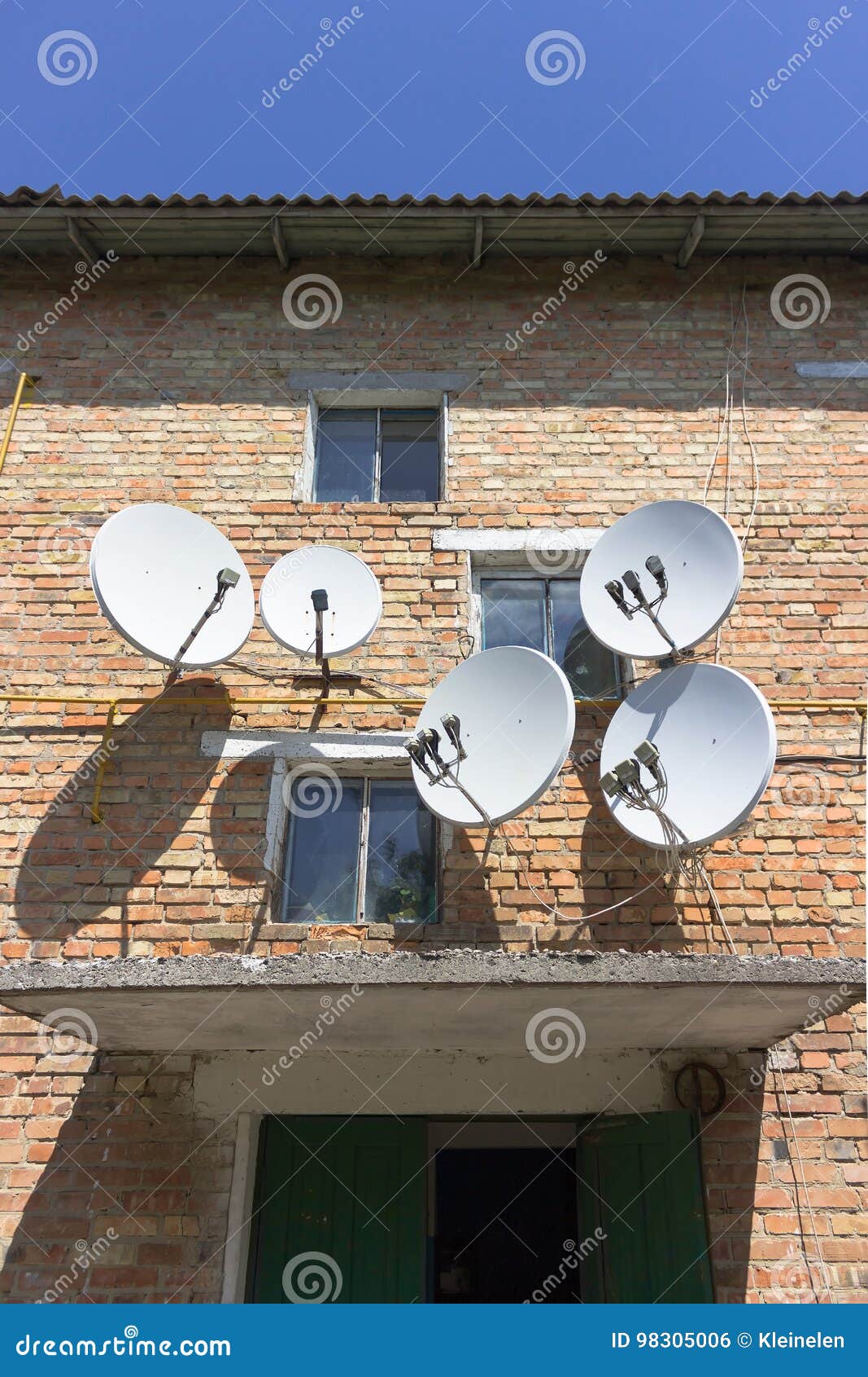 Red Brick House Wall with Satellite Dish Plate Antennas Stock Photo