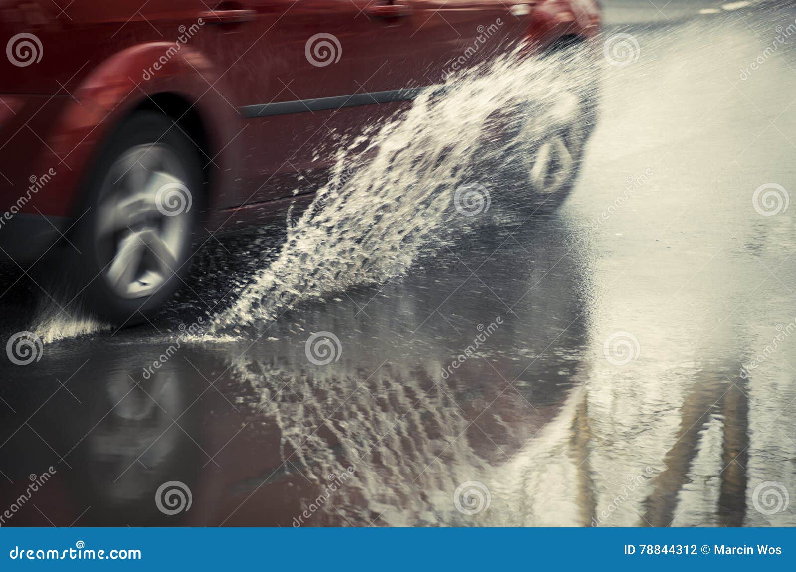 Red Car Rides on Big Puddle. Water Splash. Stock Photo Image of