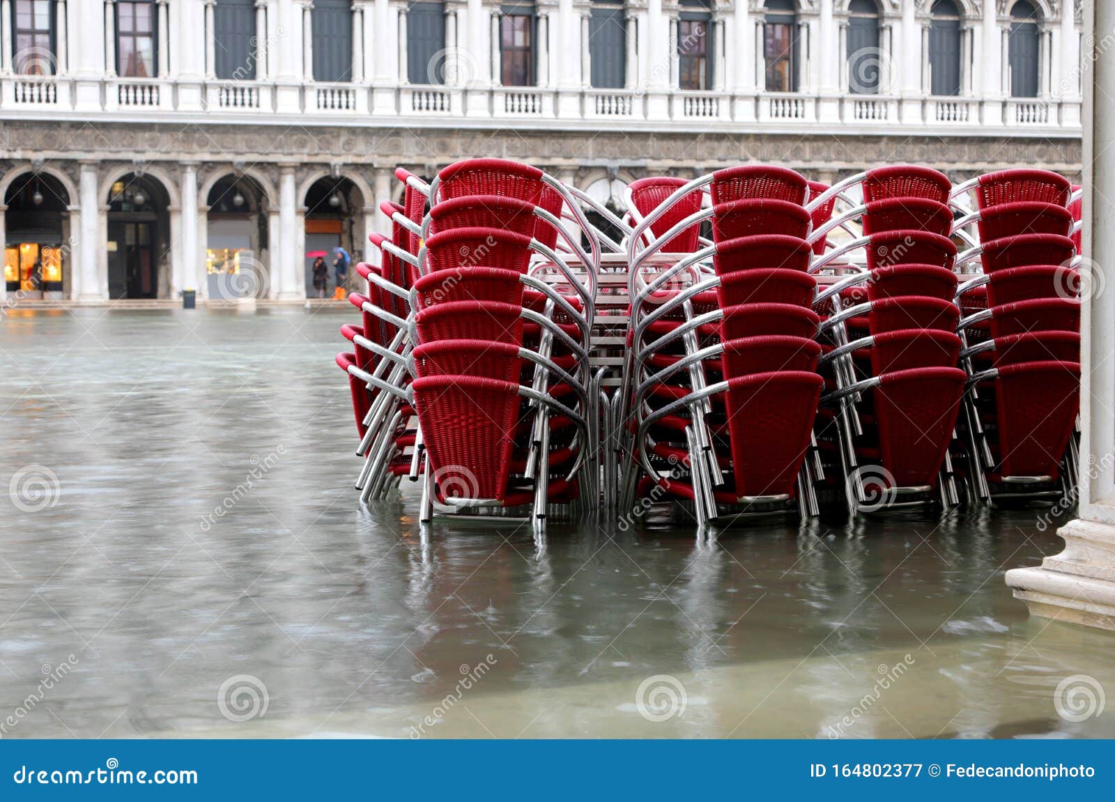 red chairs of a restaurant in venice italy with high water