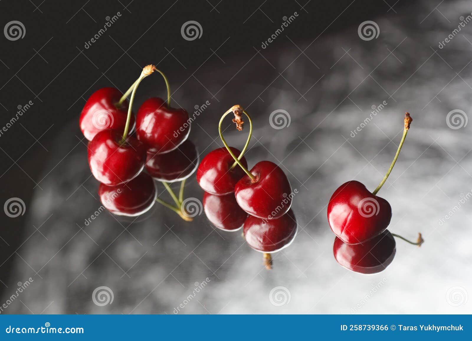 Red Cherries on a Gray Background with Reflection. Fresh Cherries on a