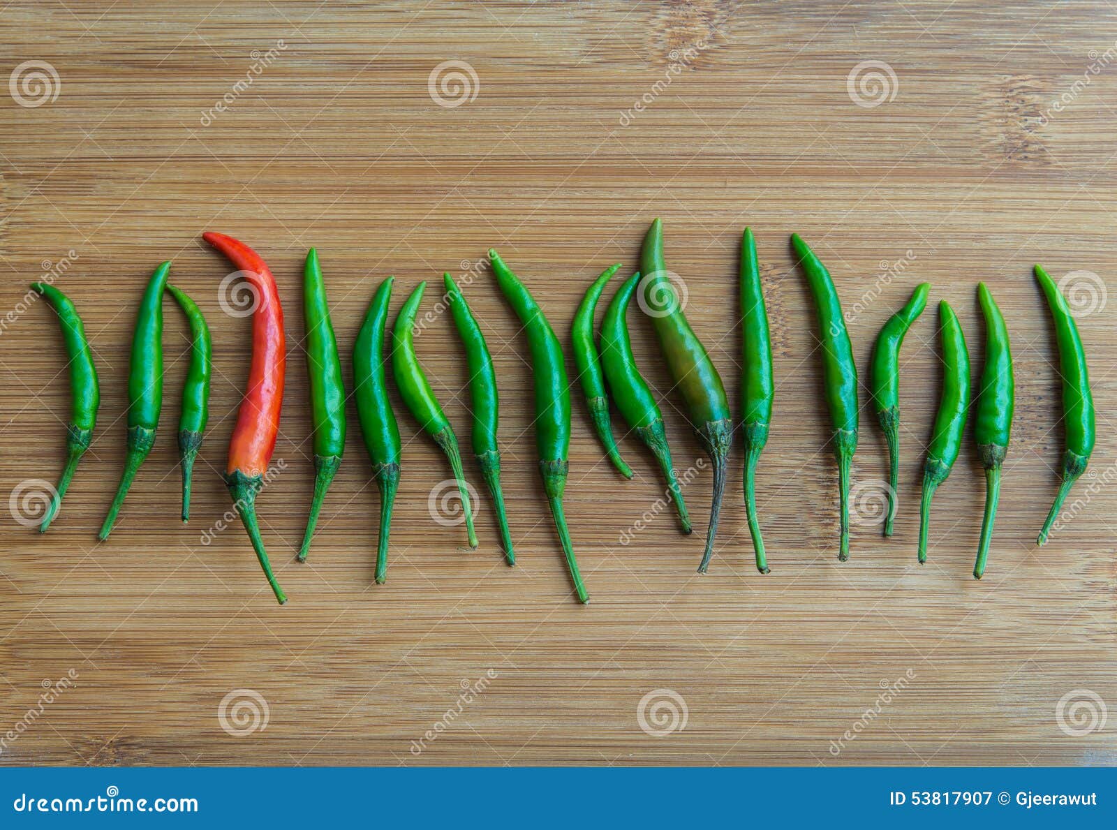 A Red Chilli Pepper in Green Chilli Pepper on Chopping Block Stock