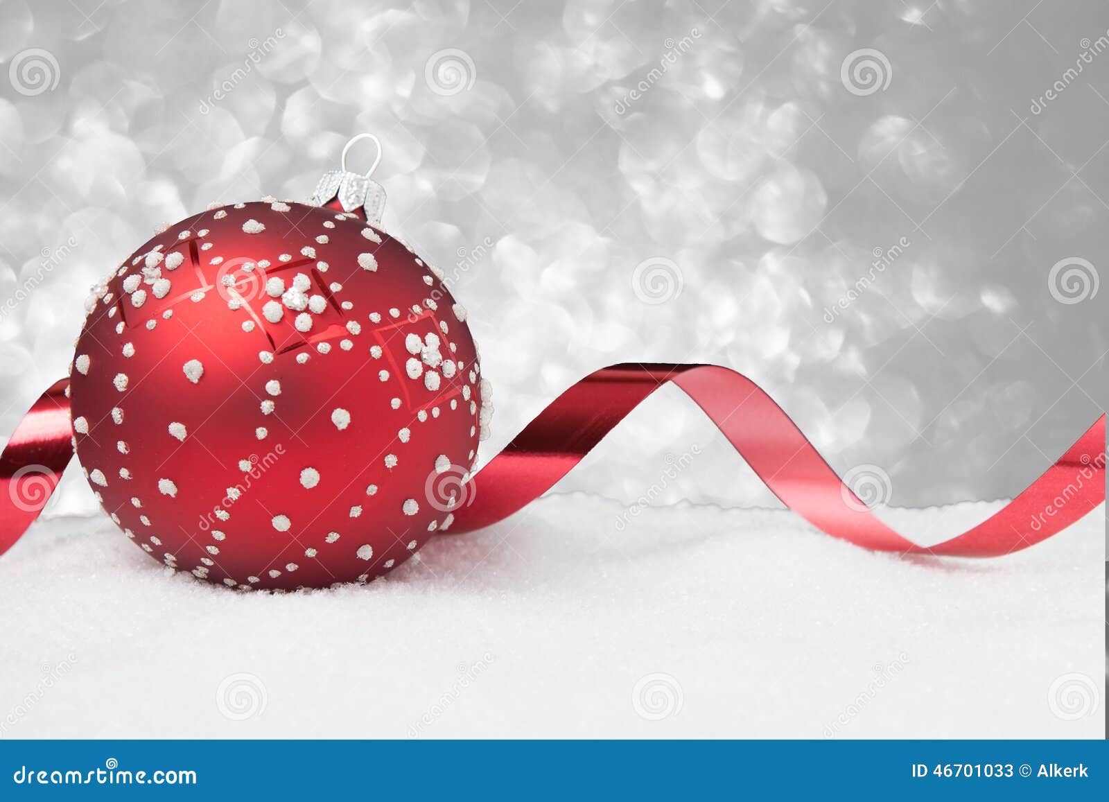 Red christmas ornament with ribbon in the snow Download preview