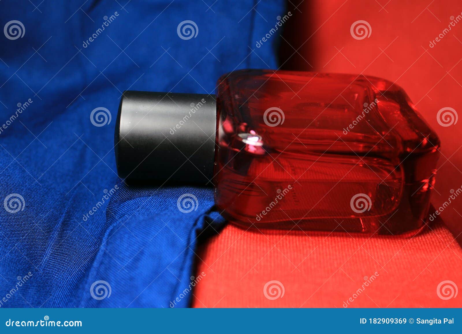 Red Color Men Perfume Bottle Isolated on Red and Blue Background. Stock ...