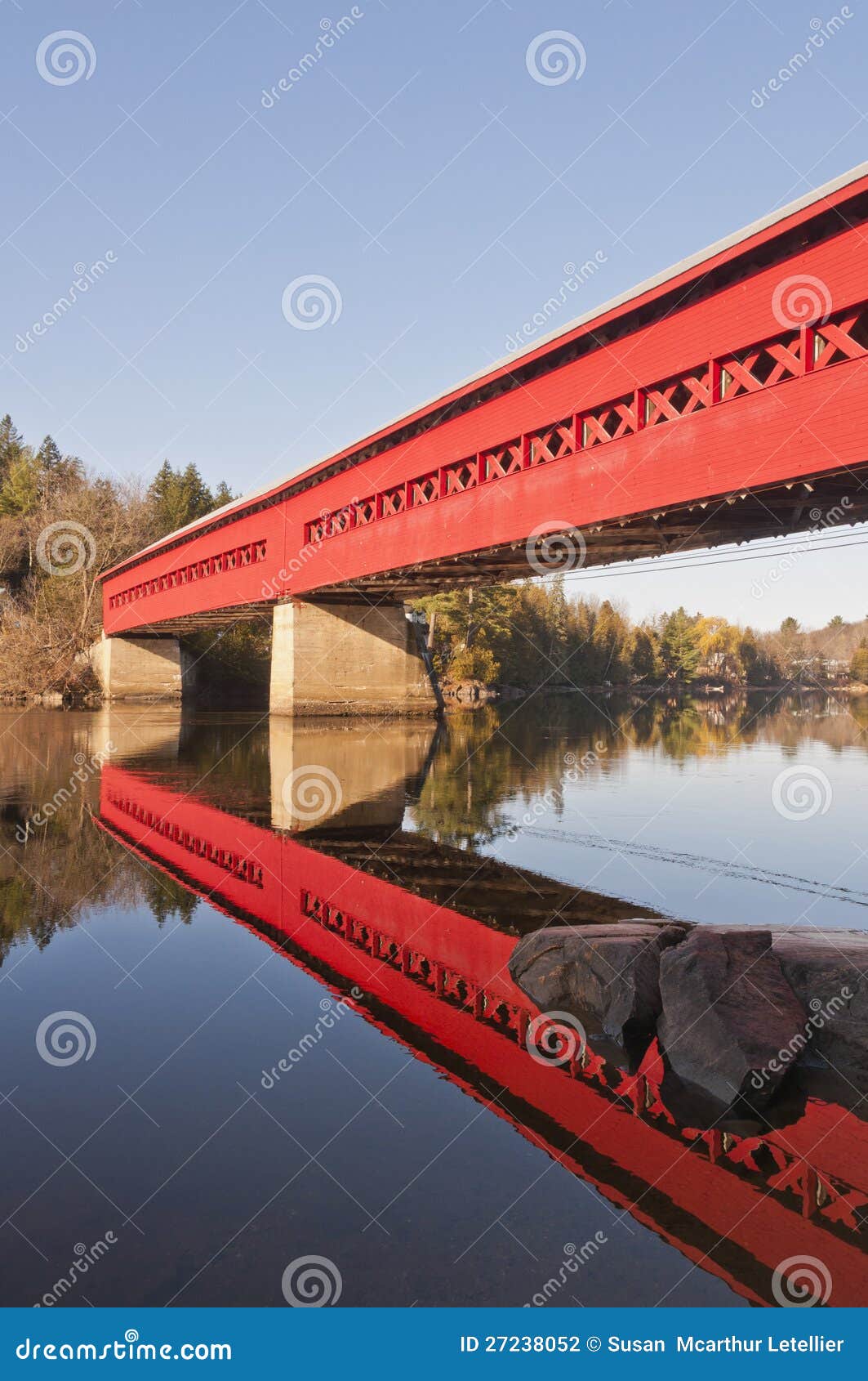 red covered bridge with reflection in water