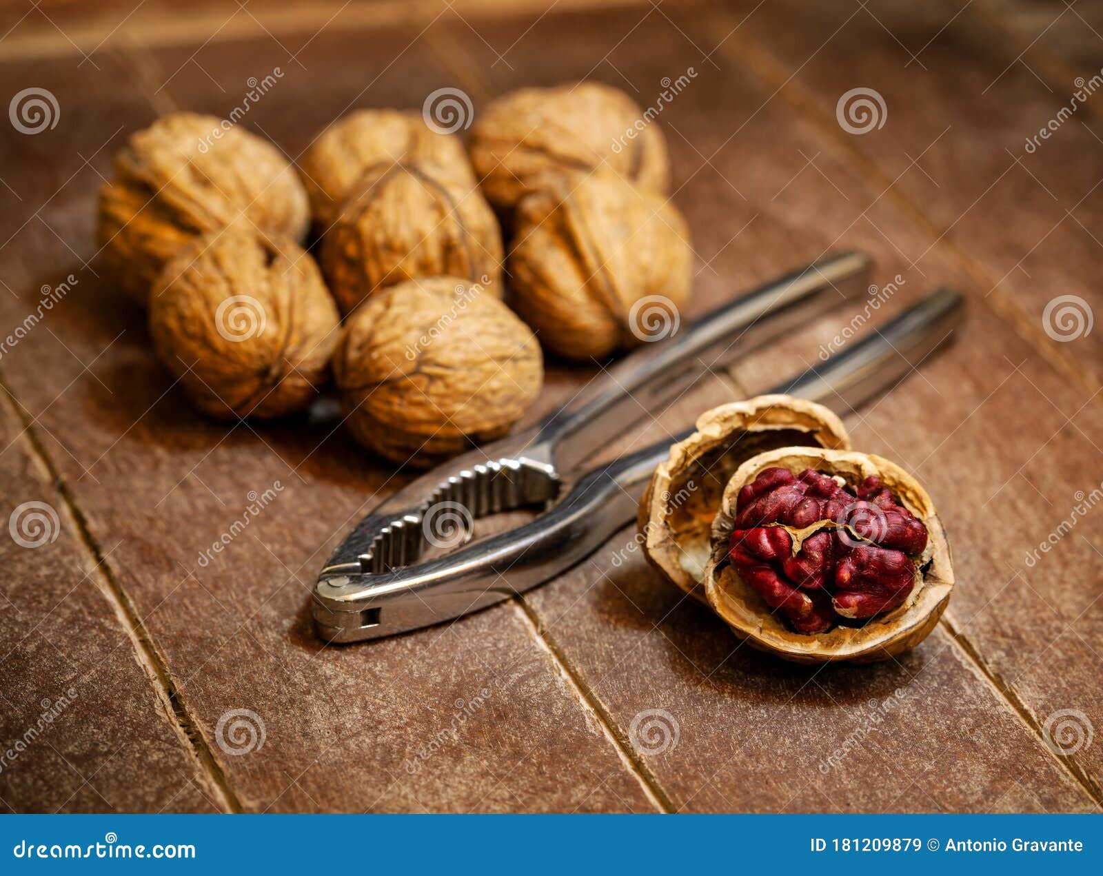 red danube walnuts with silver nutcracker on wooden background