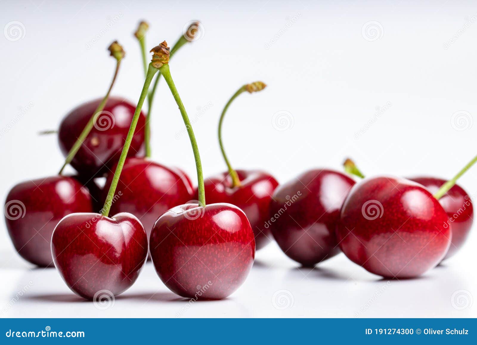 Group Of Red And Dark Red Cherries With Green Stems Top Facing Three Cherries Are In Focus On White And Light Grey Background Stock Photo Image Of Fruit Cherries