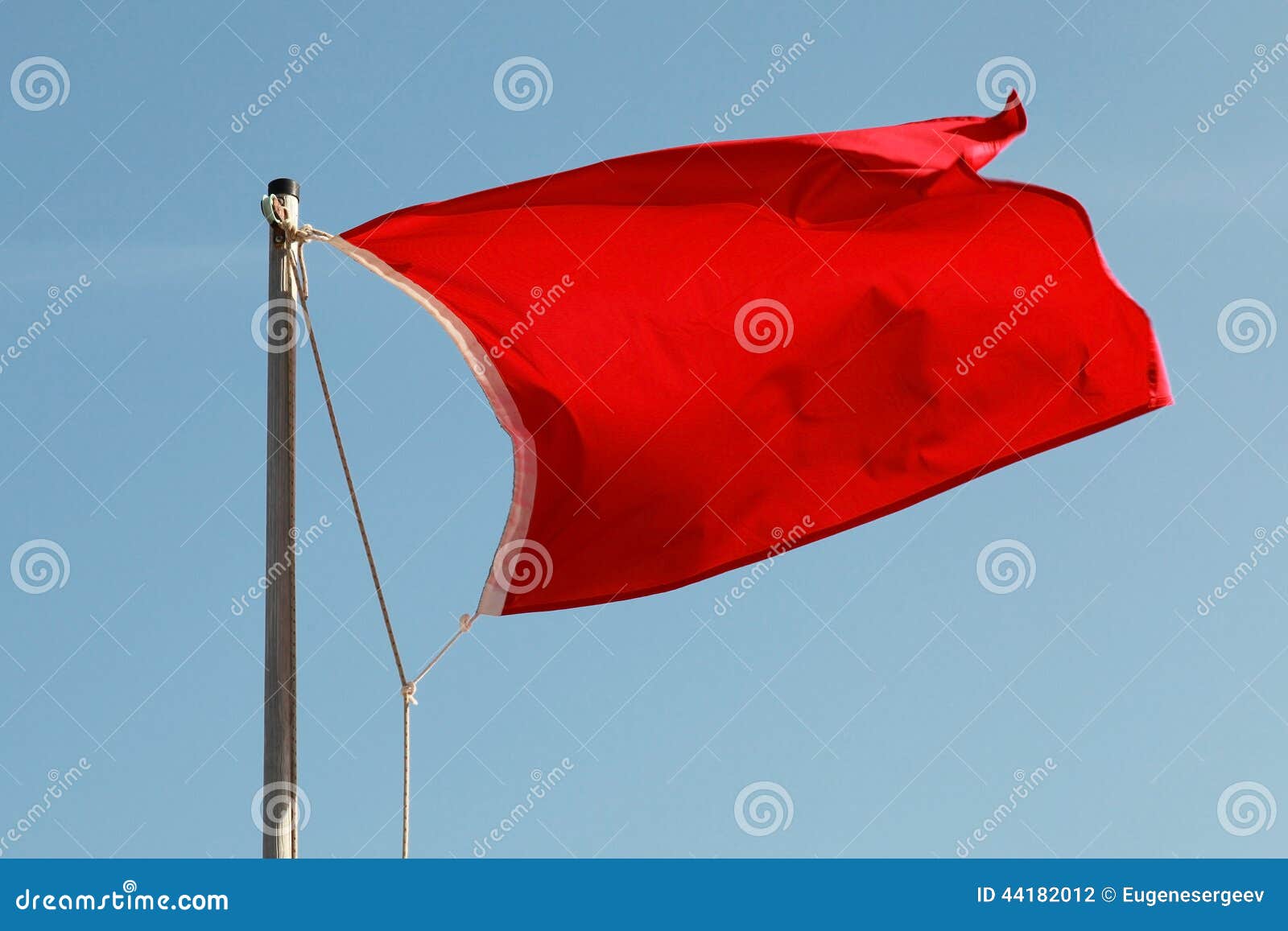 Red Flag Waving Above Blue Sky Stock Photo Image of ocean, bright