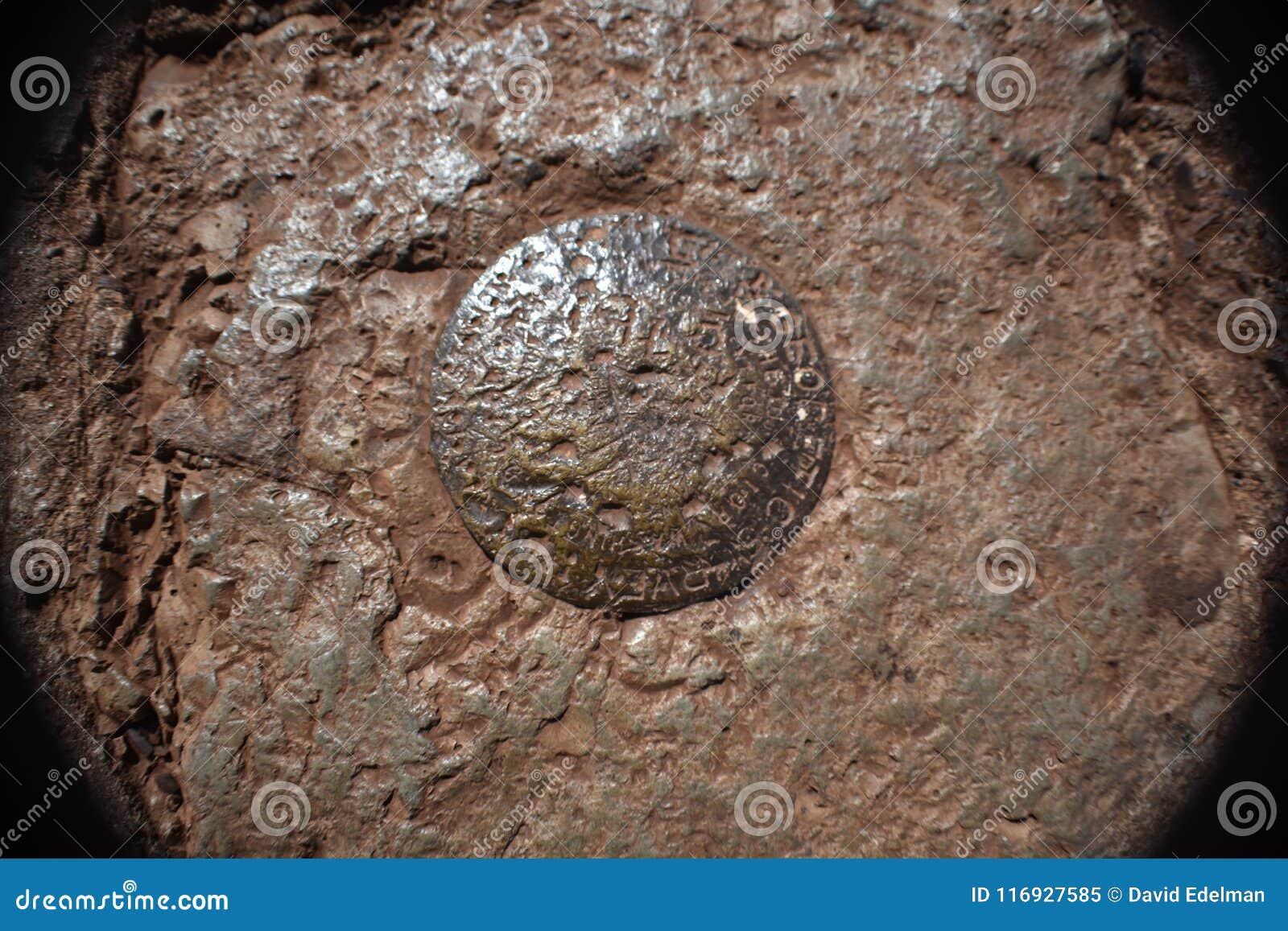 a red franciscan rock with a survey marker imbedded.