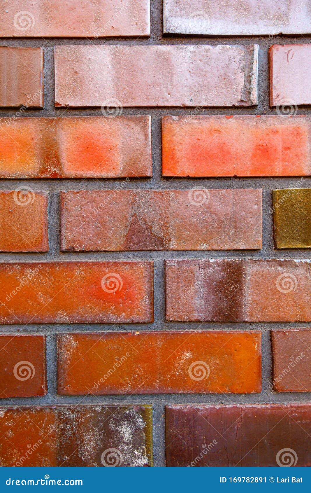 Red Glazed Brick Background. Bricks of Different Shades Closeup Stock