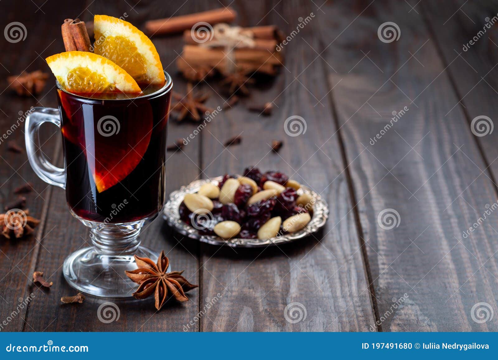 red glogg or mulled wine with orange slices and cinnamon stick on dark wooden background, horizontal, copy space