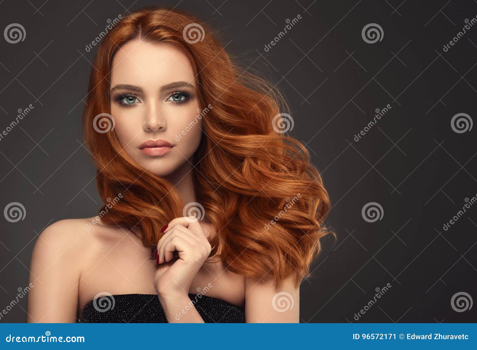 red haired woman with voluminous, shiny and curly hairstyle. frizzy hair.