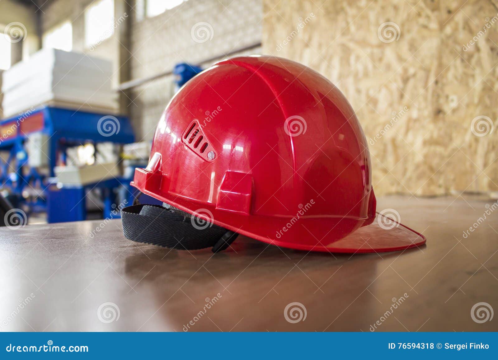Red hard hat on a table. stock photo. Image of occupational 76594318