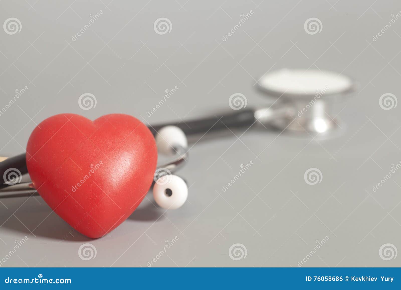 Red heart with a medical stethoscope on gray background