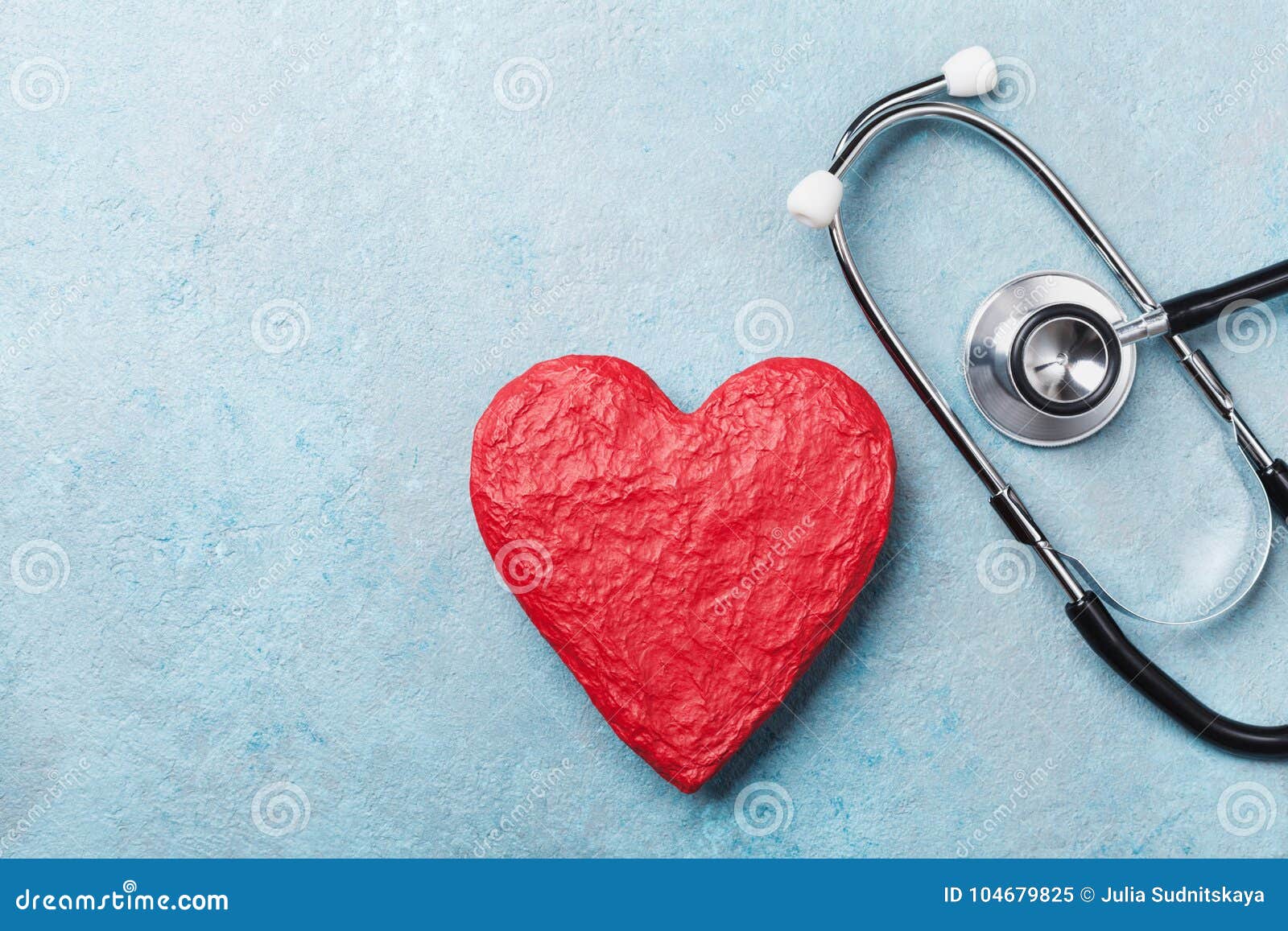 red heart  and medical stethoscope on blue background top view. health care, medicare and cardiology concept.