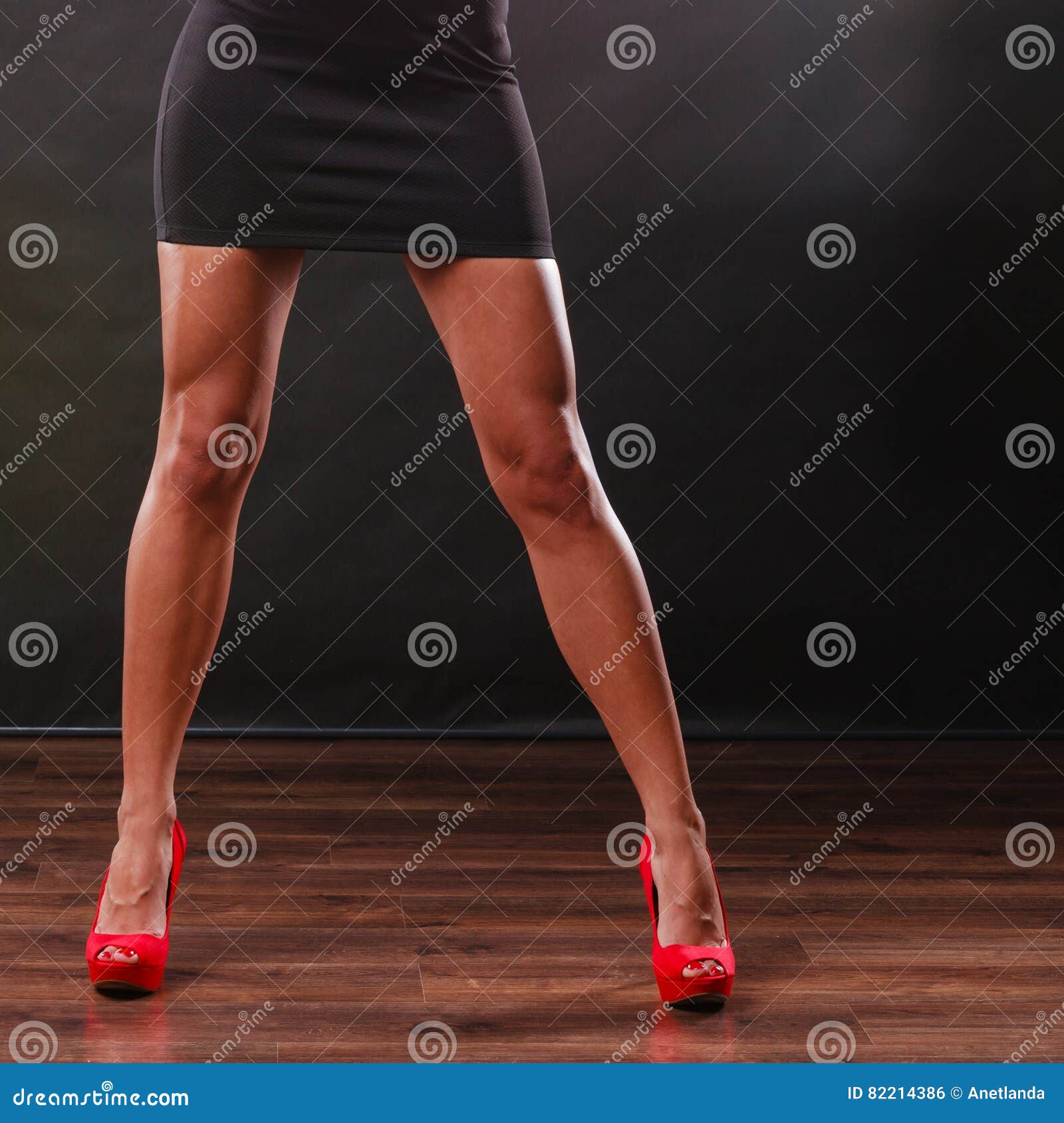 Woman legs in black high heel shoes and red dress Stock Photo by