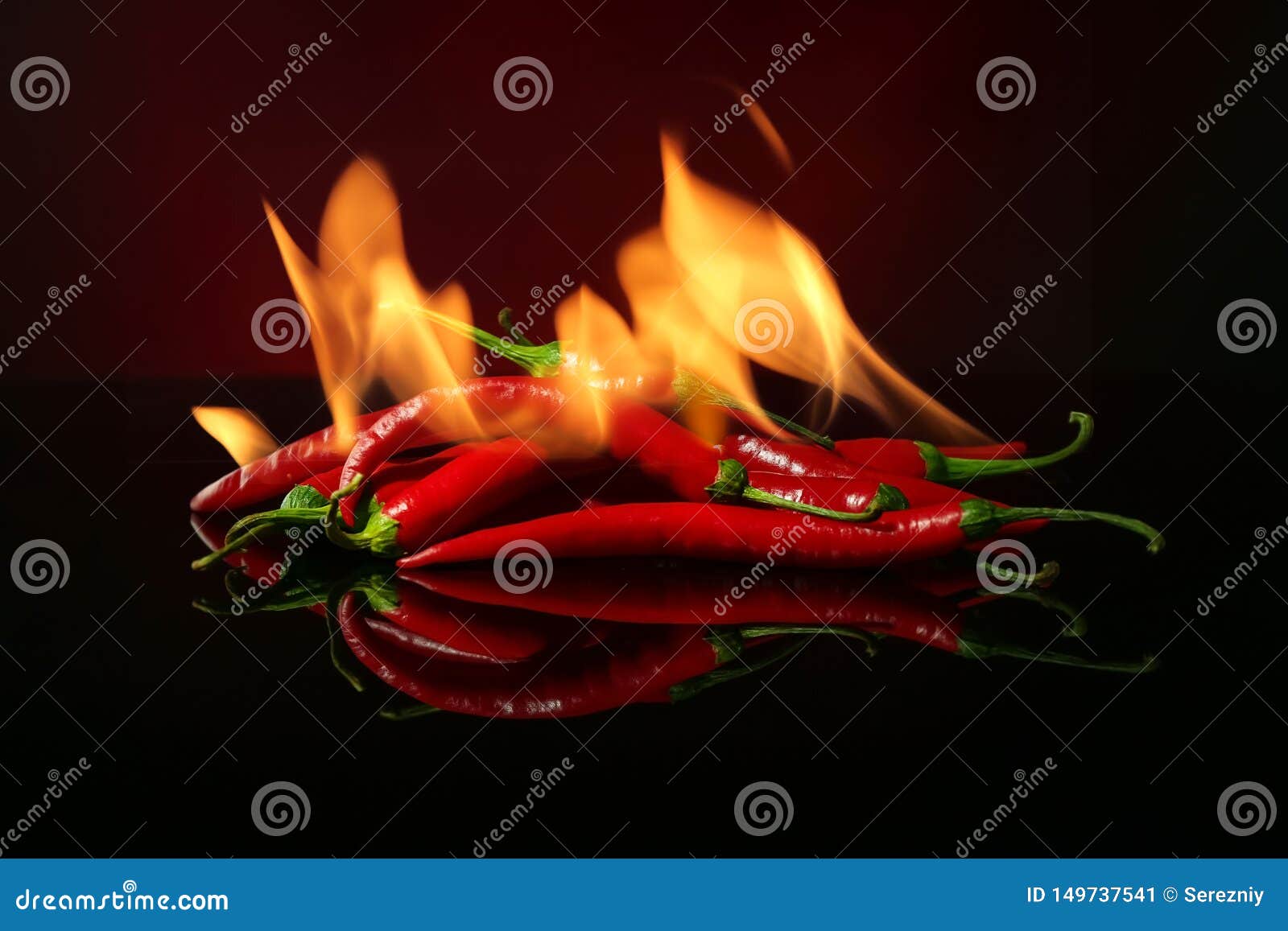 Red Hot Chili Peppers With Fire On Dark Color Background Stock Image