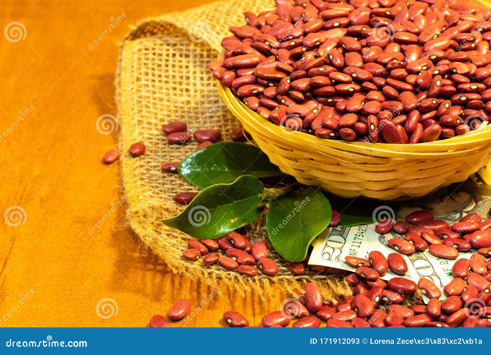 red kidney beans in a small woven basket on an artesan weave fabric, twenty usd bills