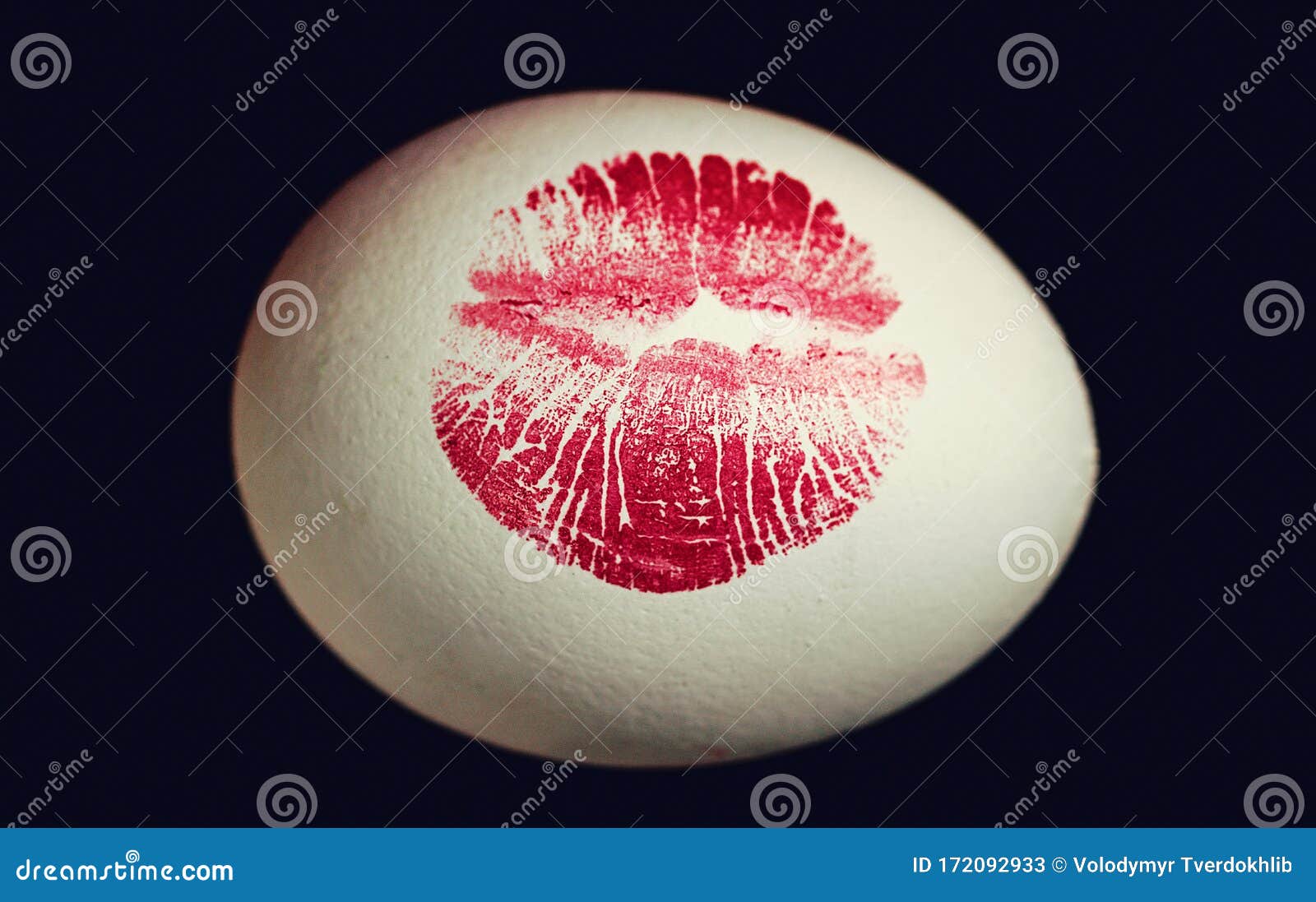 Red Lip Imprint on Easter Egg on Black Background. Print of Red Lips on