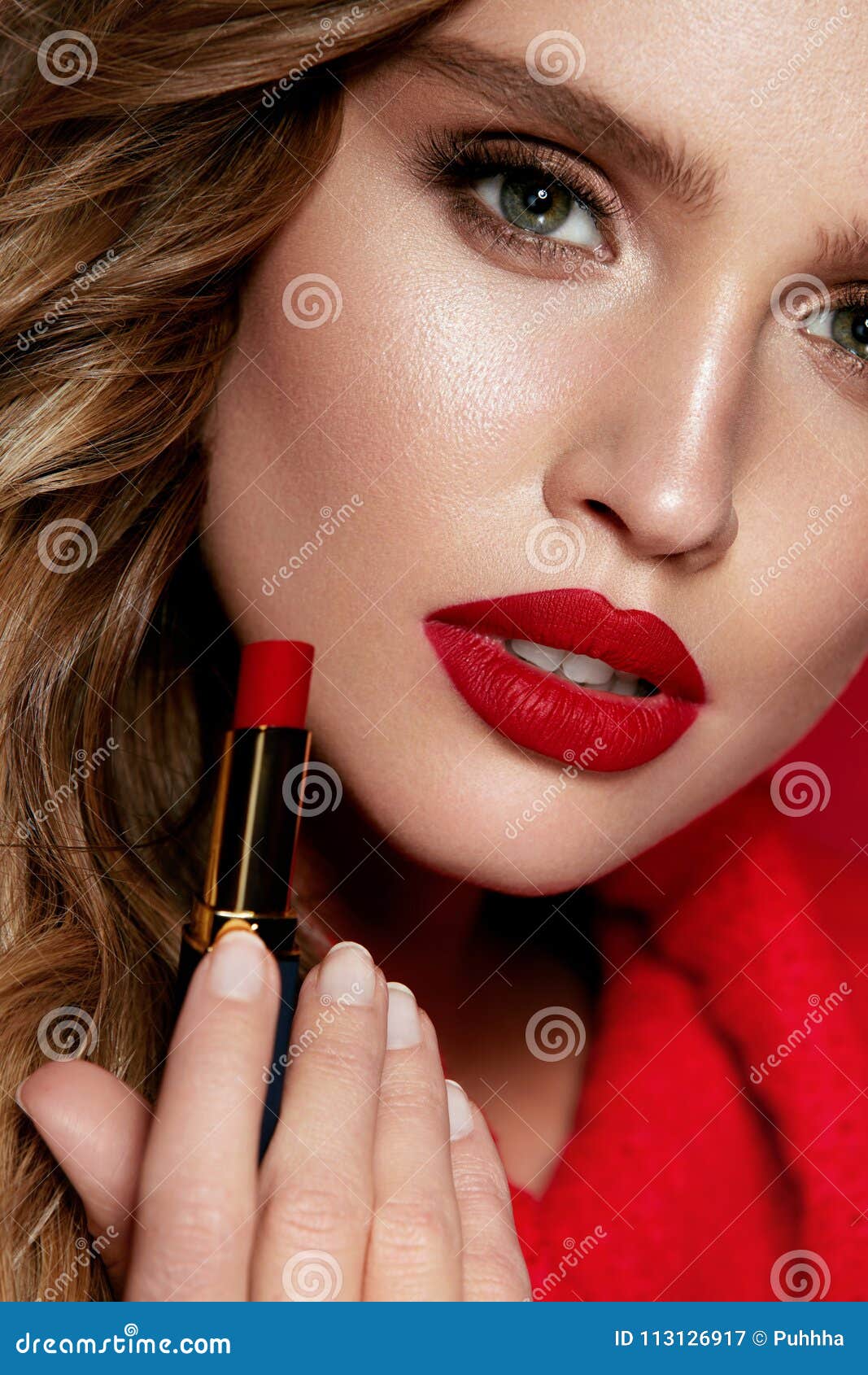 red lips. beautiful woman with beauty makeup holding lipstick.