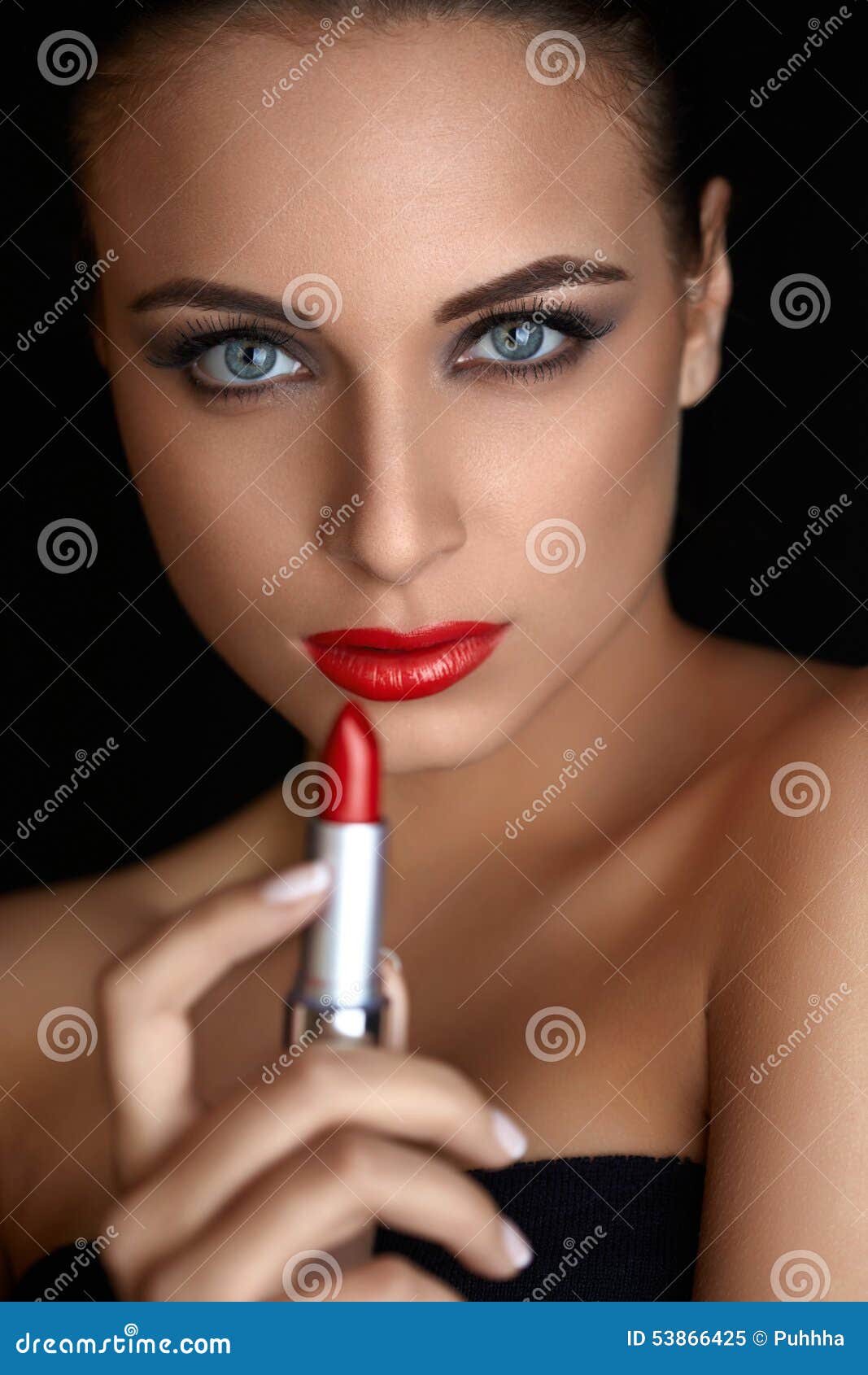 red lips. beutifull woman doing makeup applying lipstick