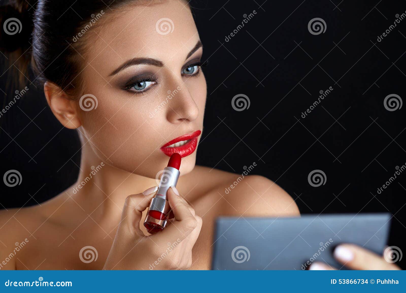 red lips. beutifull woman doing makeup applying lipstick