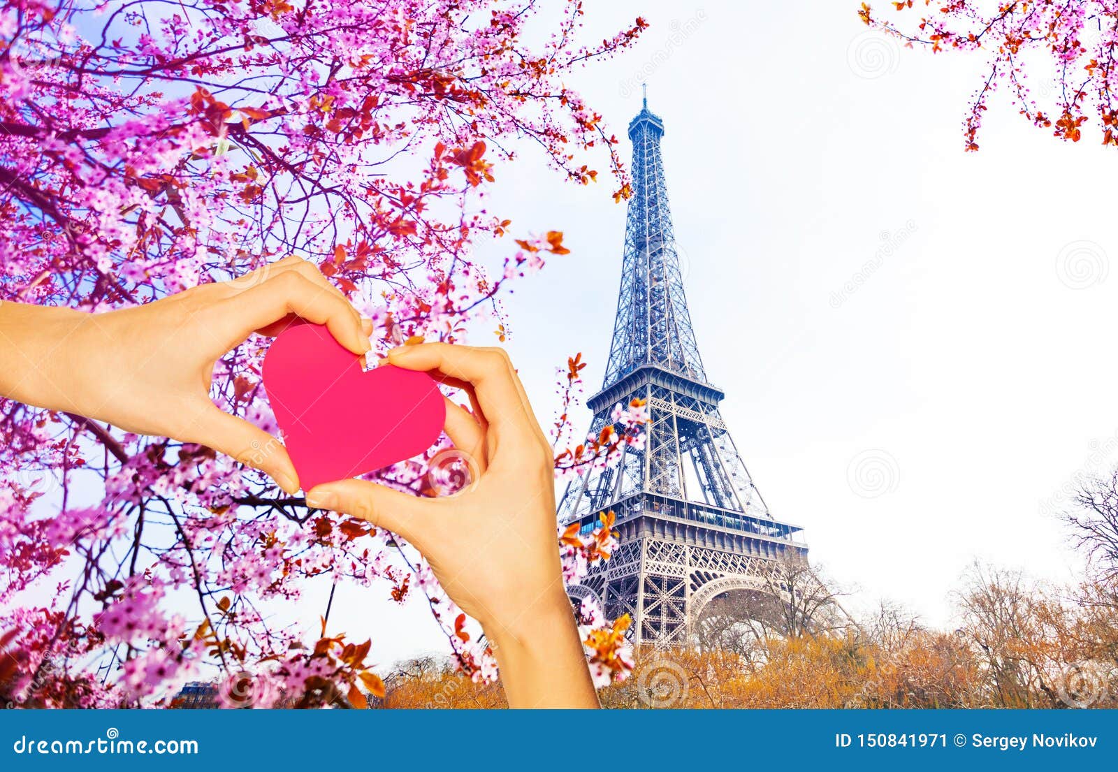 hand hold red heart over the eiffel tower