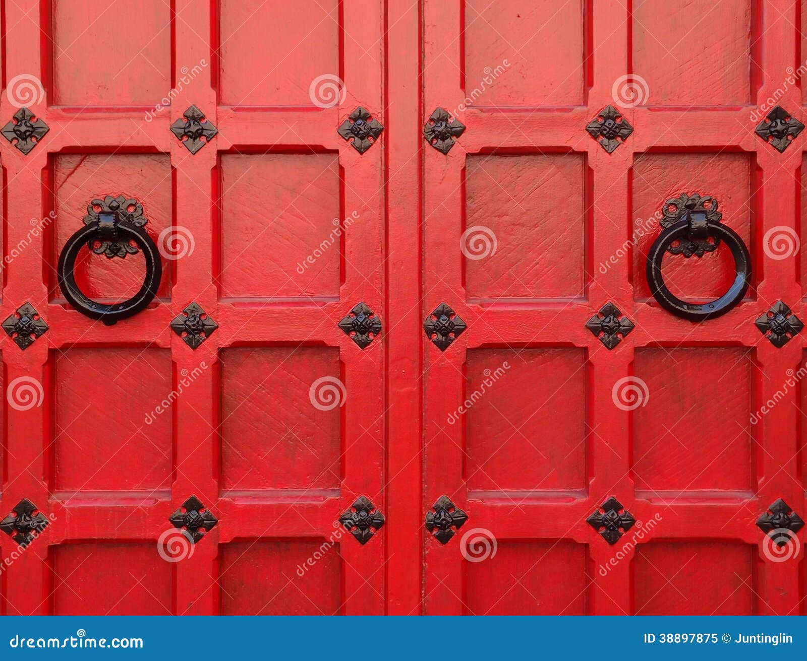 Red Medieval Doors with Black round handles and metal decoration.
