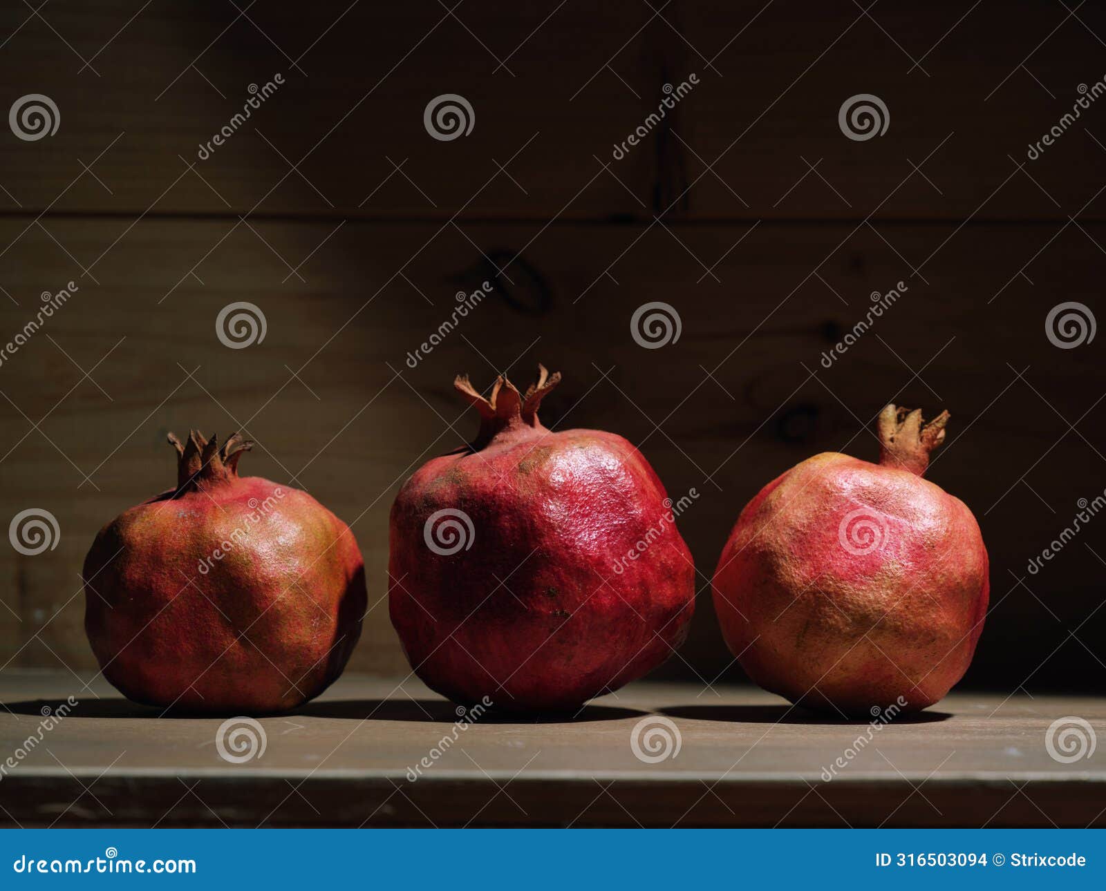 red organic grown pomegranates in bright sunlight with copyspace. natural fruit concept image