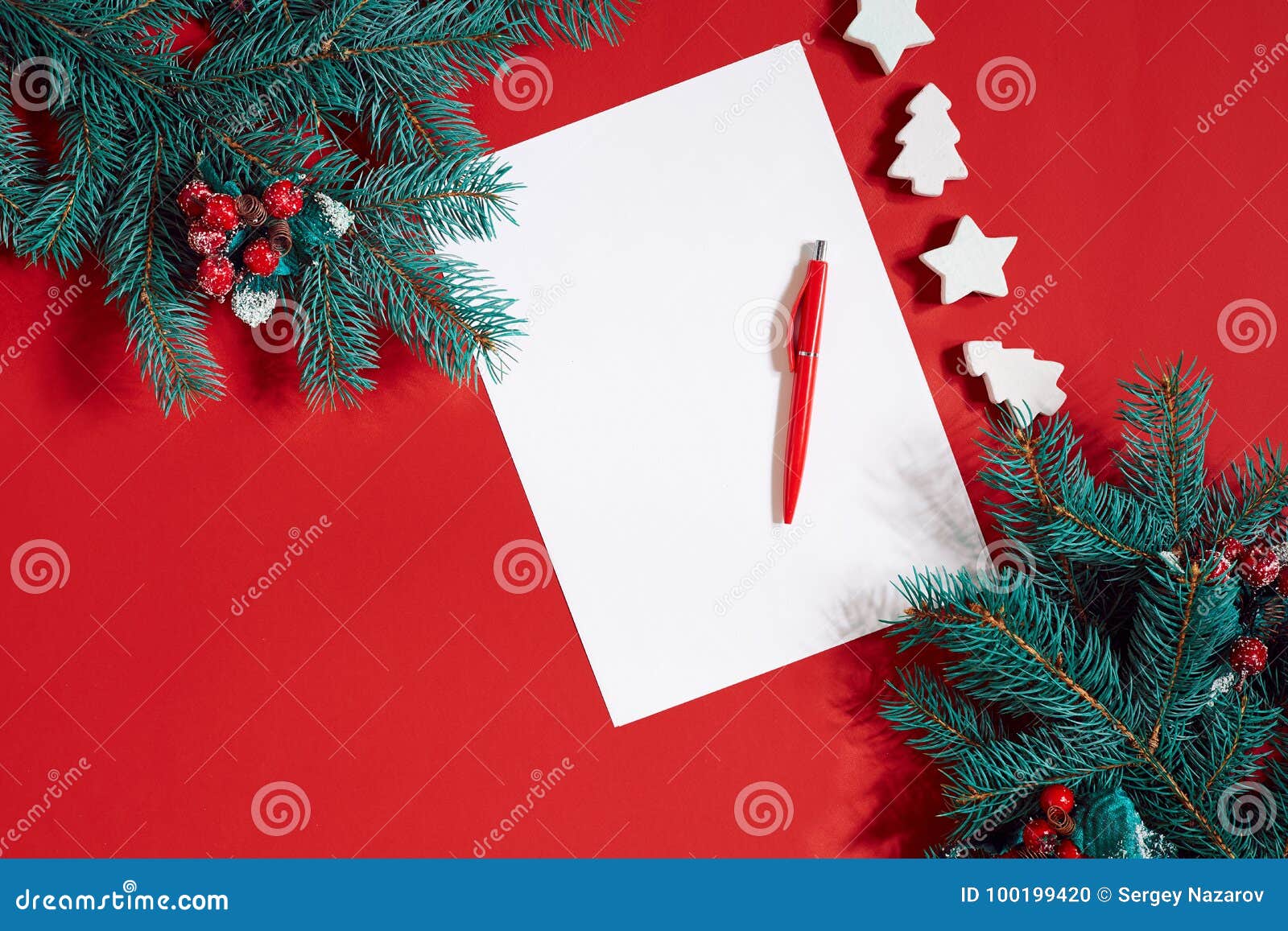 Red Pen and Notepad on Red Table Decorated with a Fir Branch. the