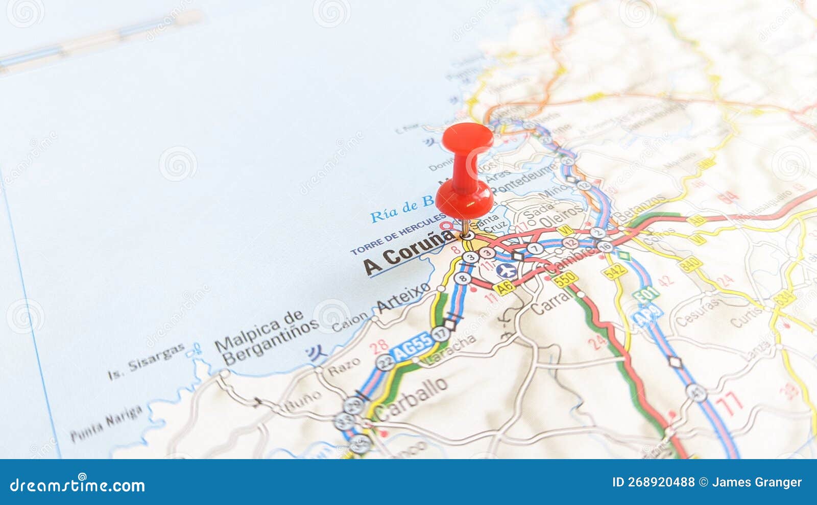 a red pin stuck in a coruna on a map of spain