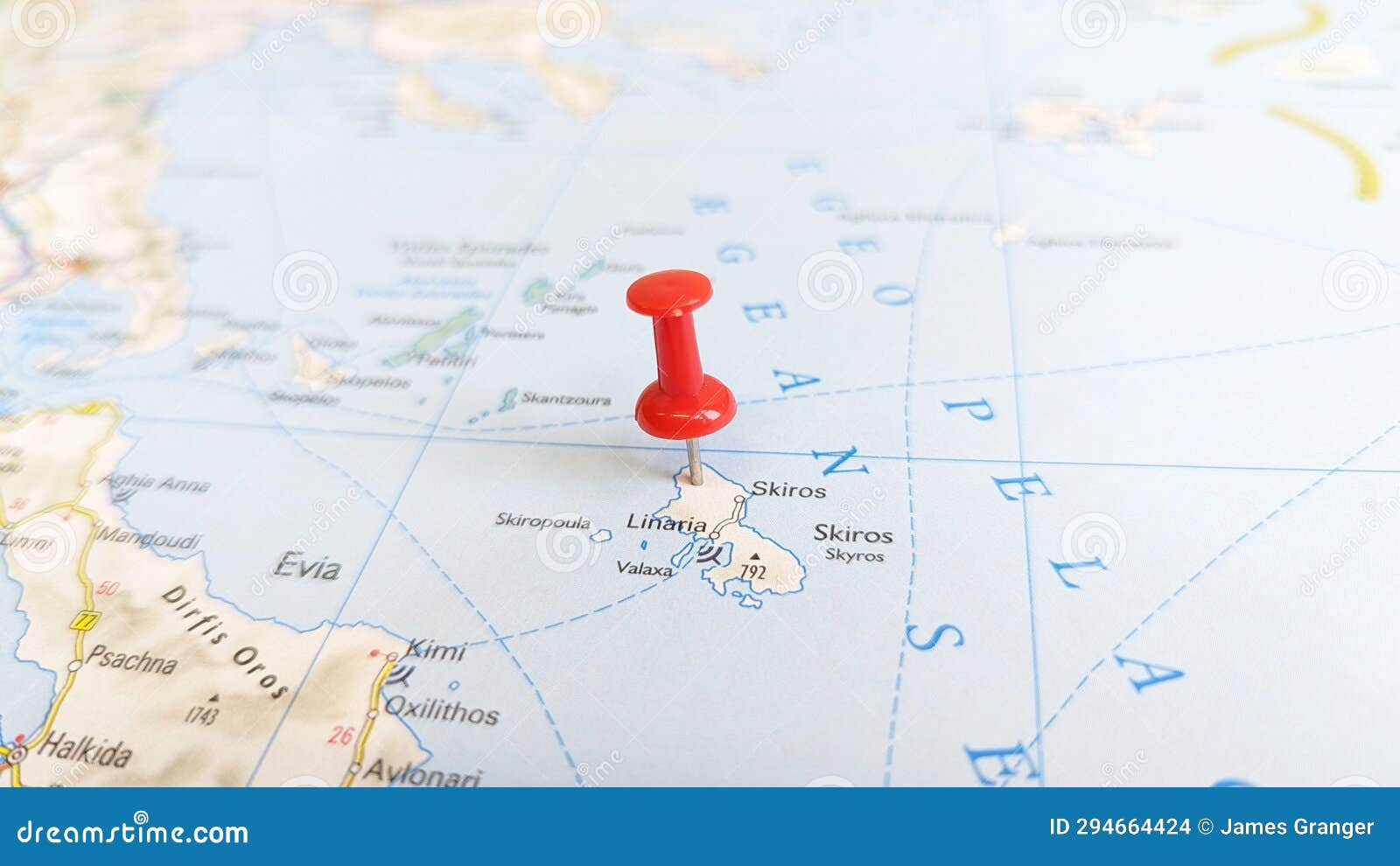 a red pin stuck in the island of skyros skiros on a map of greece