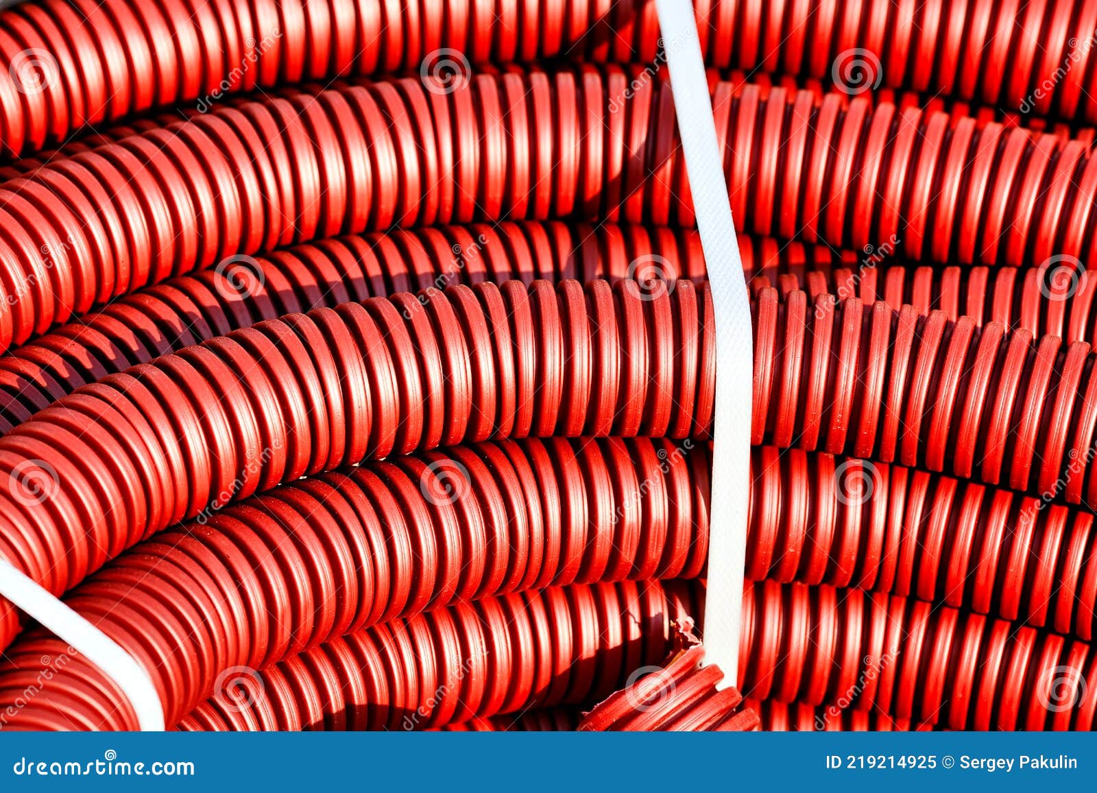 Red Plastic Corrugated Hose for Insulation and Laying of Wires and Cable Closeup. Stock Image