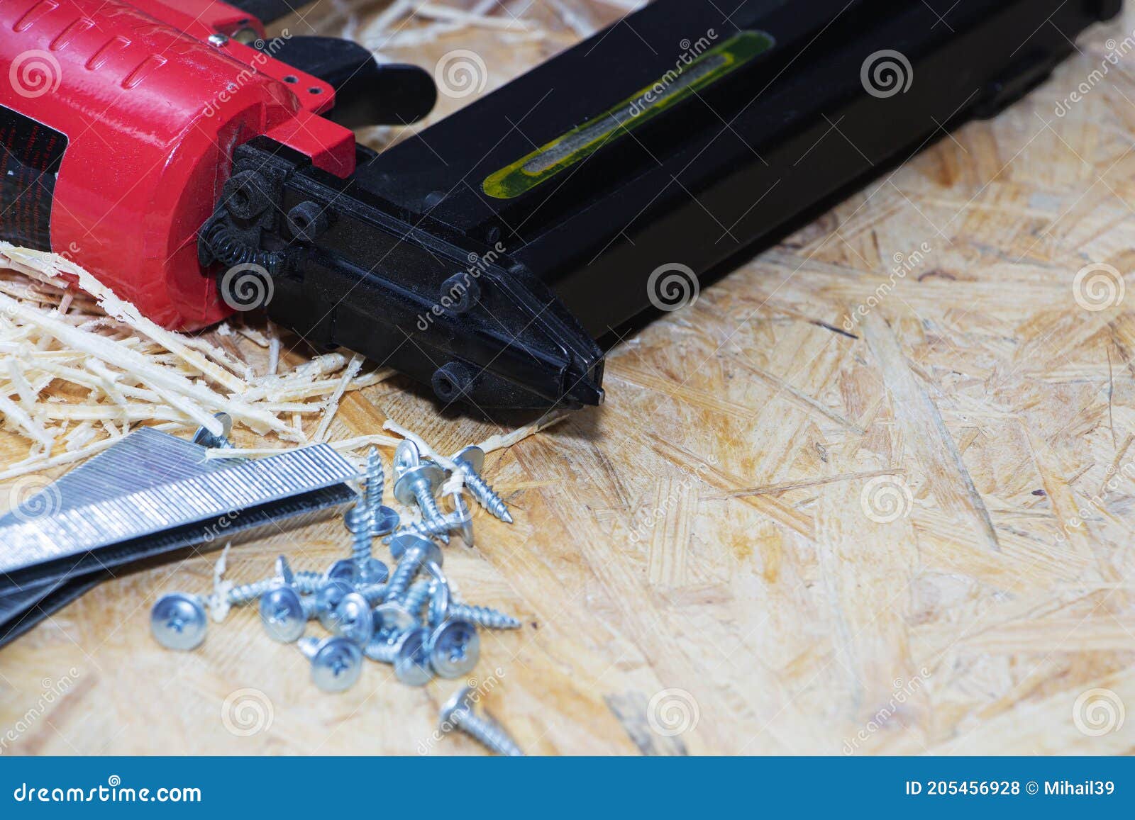 Red Pneumatic Construction Stapler and a Stack of Staples for the Stapler. Stock Photo Image