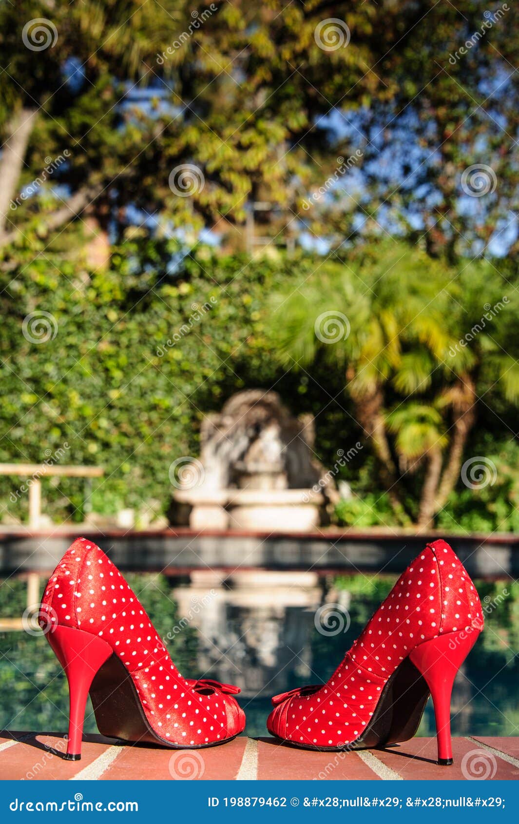 red polka dot high heels at pool`s edge
