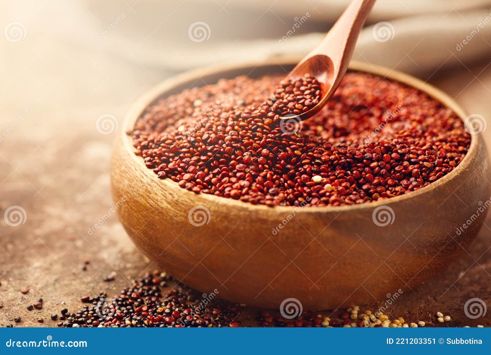 red quinoa grains in a wooden spoon. healthy food in a bowl. seeds of red quinoa - chenopodium quinoa. healthy vegan food