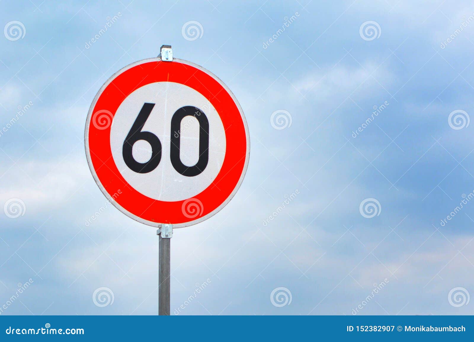 Red Round 60km h Speed Limit Sign On Highway In Front Of Blue Sky Stock red-round-60km-h-speed-limit-sign-on-highway-in-front-of-blue-sky-stock