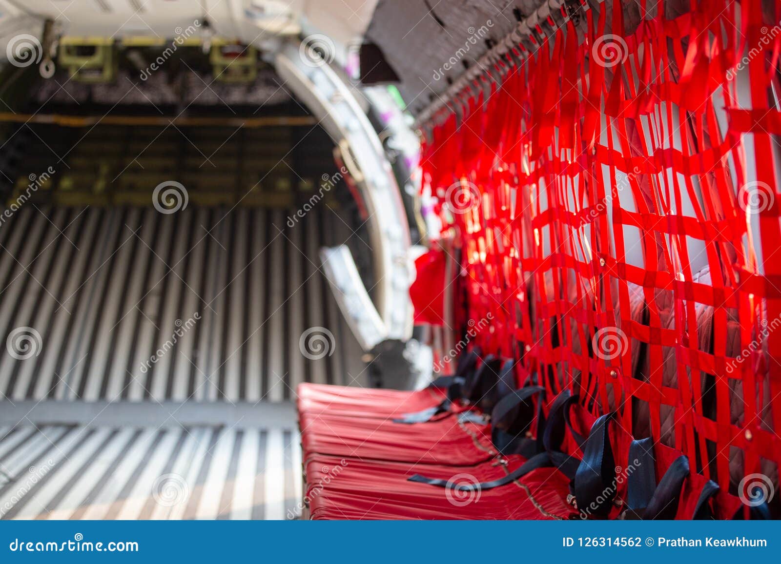 red seat with seatbelt for paratrooper or airborn forces in military transport aircraft cabin