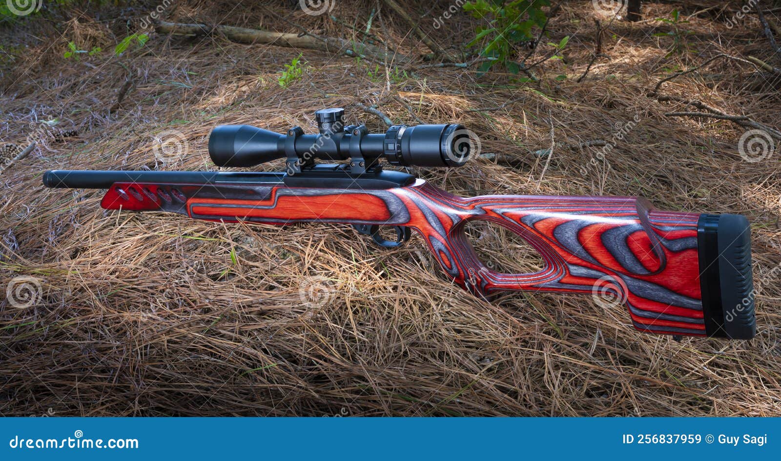 red semi-auto rimfire rifle with optic on the ground