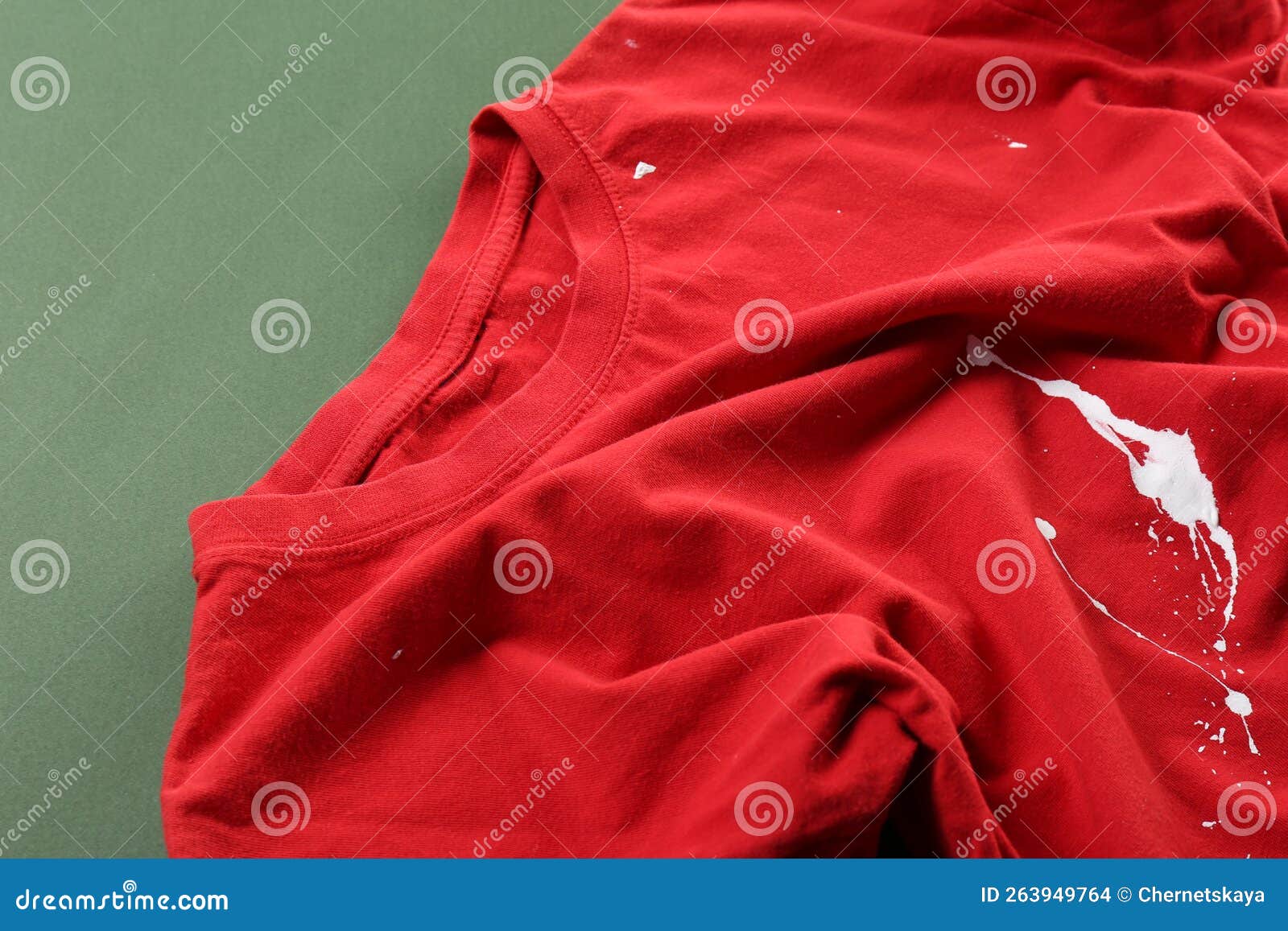 Red Shirt with White Paint Stain on Green Background, Above View Stock ...