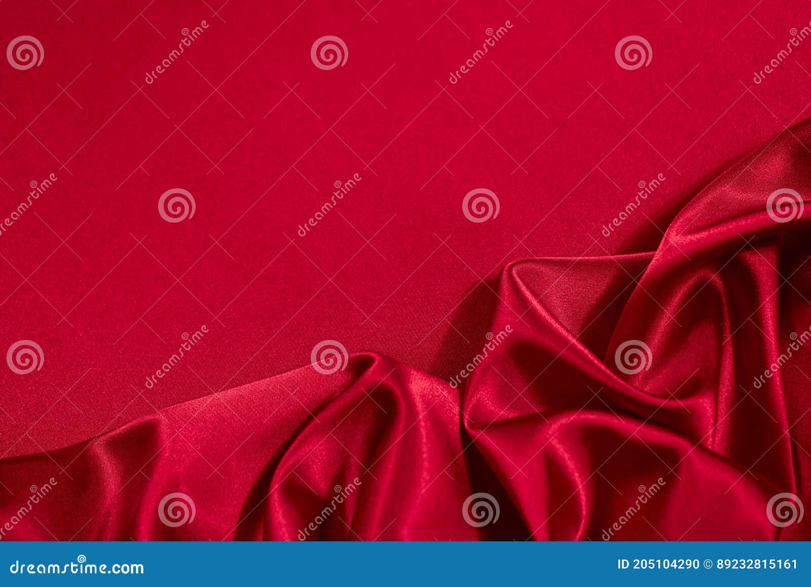 red silk satin background. copy space for text or product. wavy soft folds on shiny fabric.