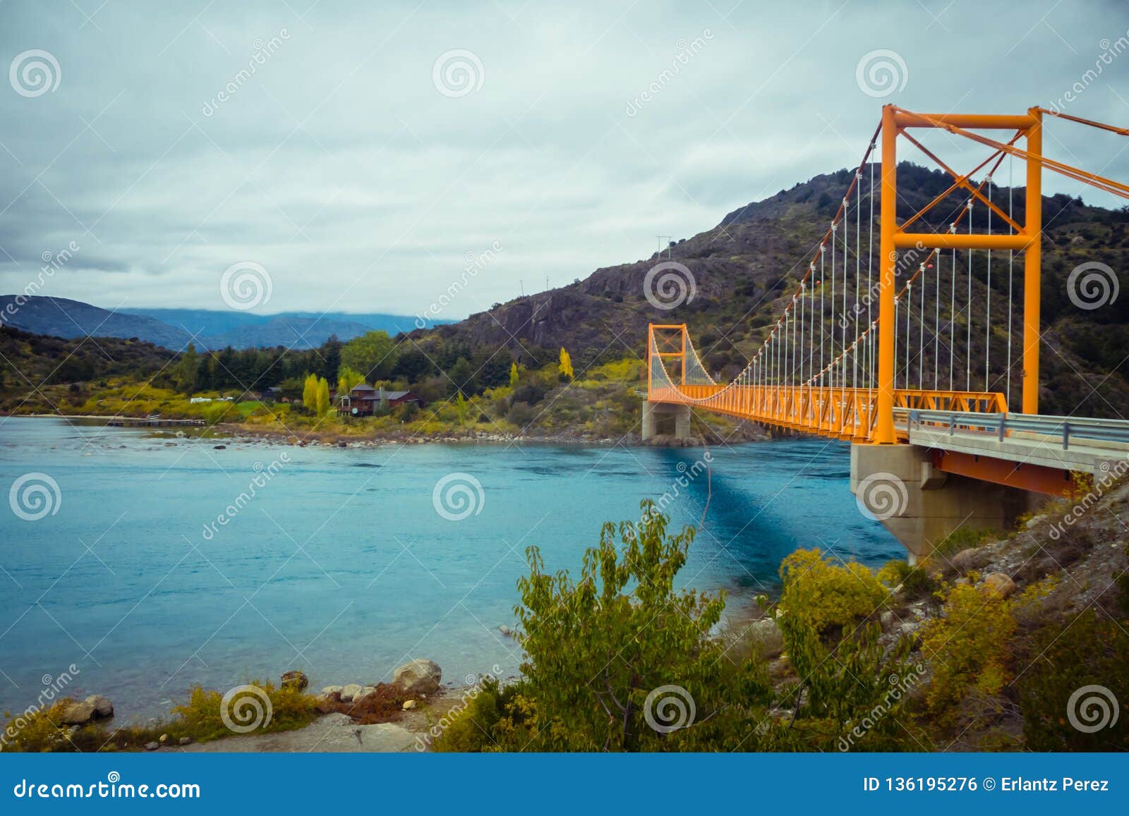 red suspension bridge over the water runoff of general carrera lake, near lake bertrand, puerto tranquilo, chile chico, aysen,